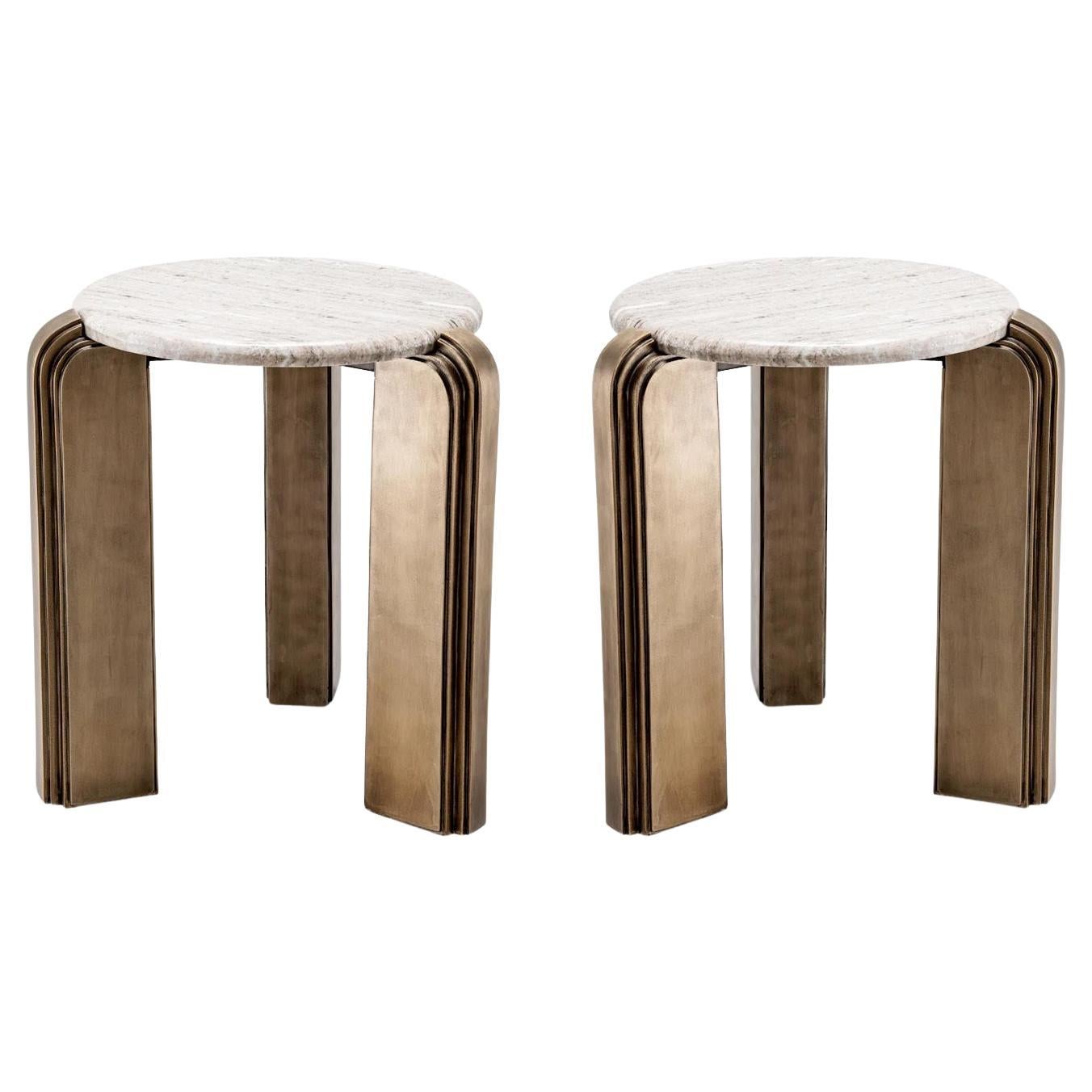 Coppia di sofisticati tavolini, finitura in ottone antico, piano in marmo beige.