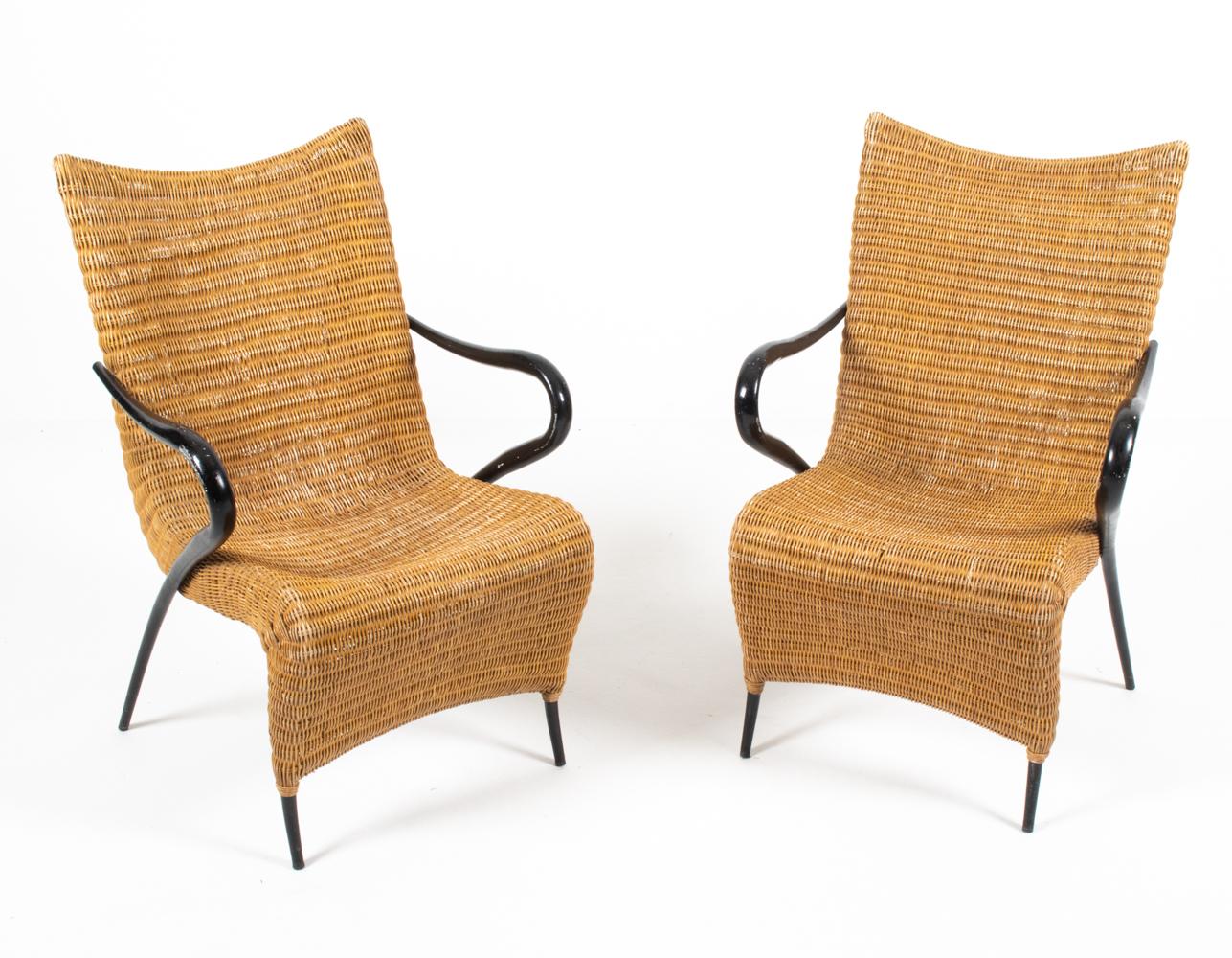 A rare and unusual pair of Danish modern easy chairs in sculpturally formed rattan with elegantly sloping arms in black paint finish. Designed by Soren Lund for Soren Lund Mobler, second half of the 20th century. These atomic age-influenced lounge