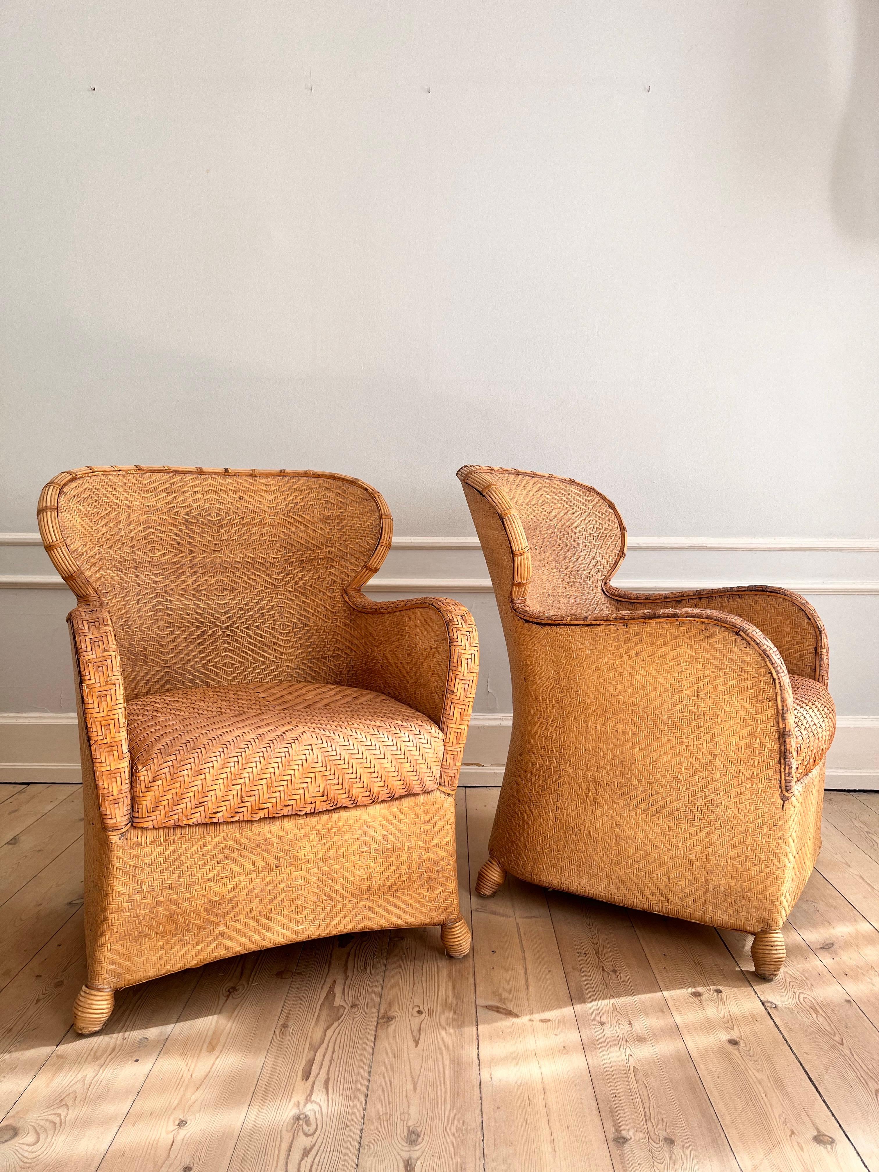 A pair of Søren Lund armchairs in cane and leather. 

The chairs are from the 1960s and have a really good seating comfort. The huge leather cushion is soft and great to sit on. 

Both chairs are colonial style and sculpturel. They will fit in every