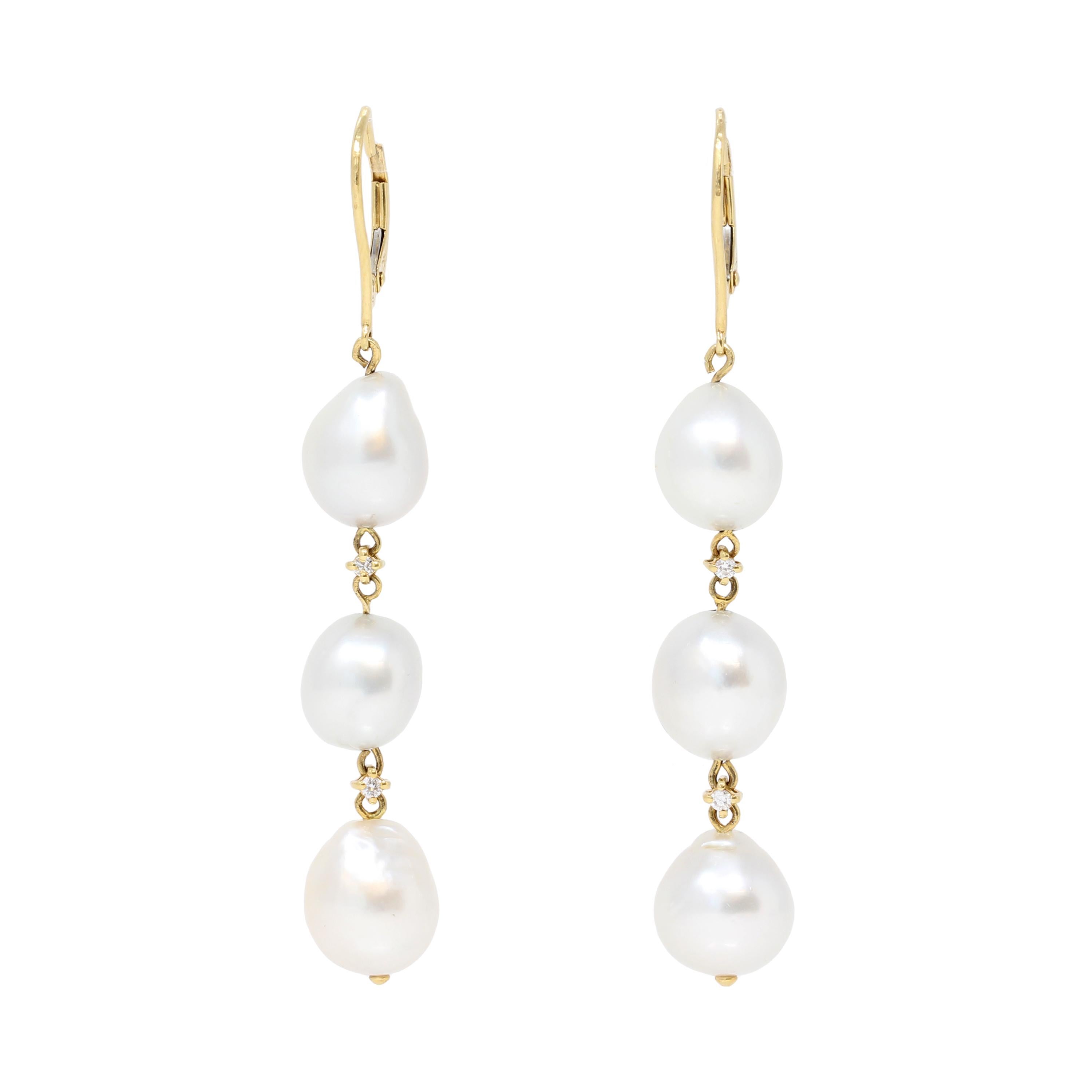 A pair of dangling South-Sea baroque pearl earrings in 18K yellow gold with diamond accents. Made at the beginning of the century,  these earrings feature three 10 to 11-millimeter pearls with very good luster and minor surface inclusions. The