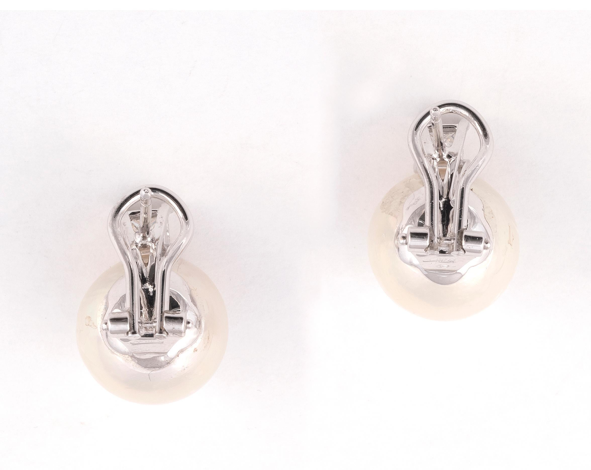 les perles blanches de 14 mm surmontées de diamants taillés en brillant, diamants d'environ 0,45 ct au total.

