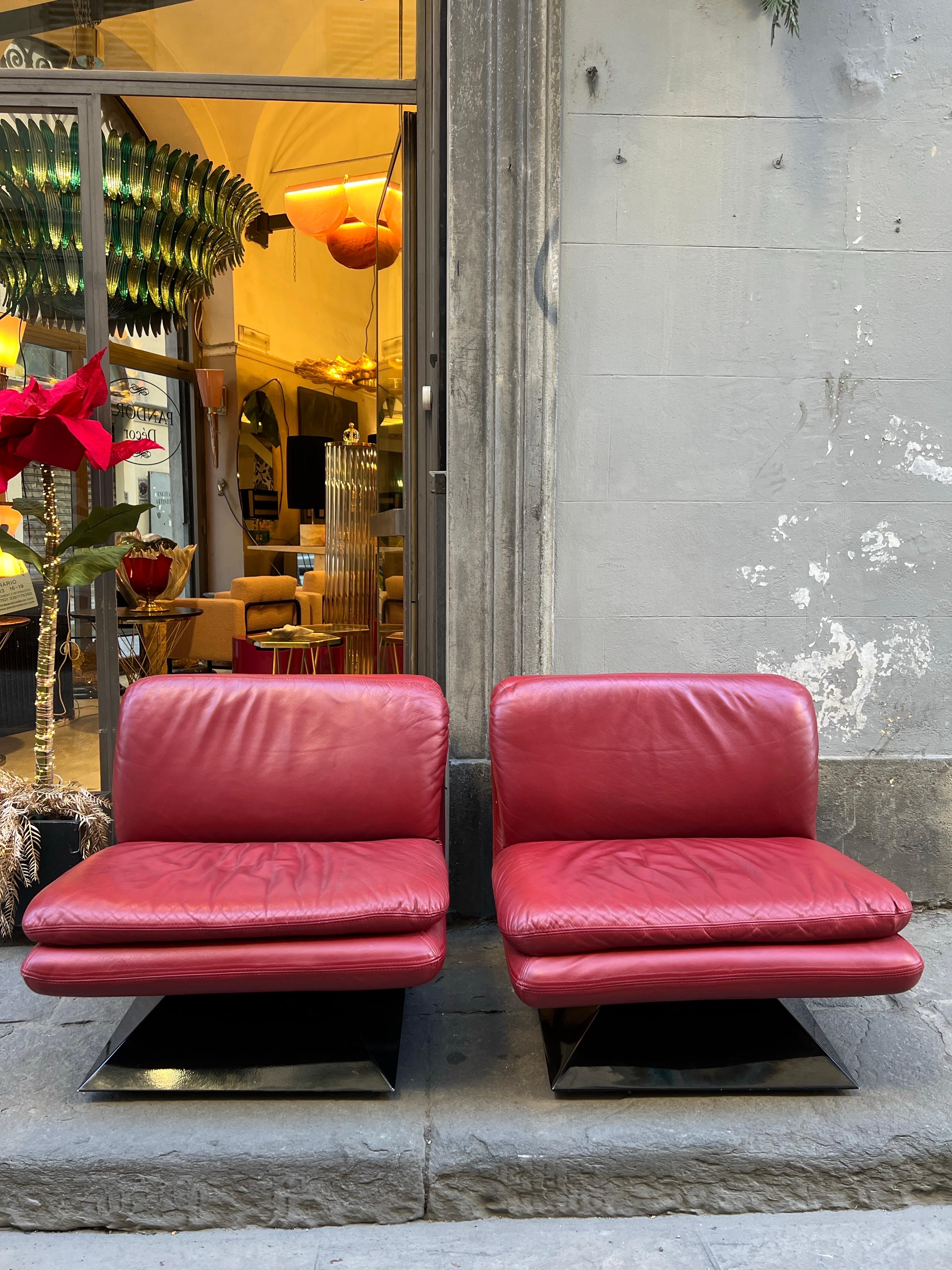 Ein Paar Space Age Lounge Sessel aus rotem Leder auf einem konisch geformten, schwarzen Acrylsockel mit quadratischem Querschnitt.
Space Age Design ist eine Kunstrichtung, die in den 1960er und 1970er Jahren entstanden ist und sich durch Kühnheit,