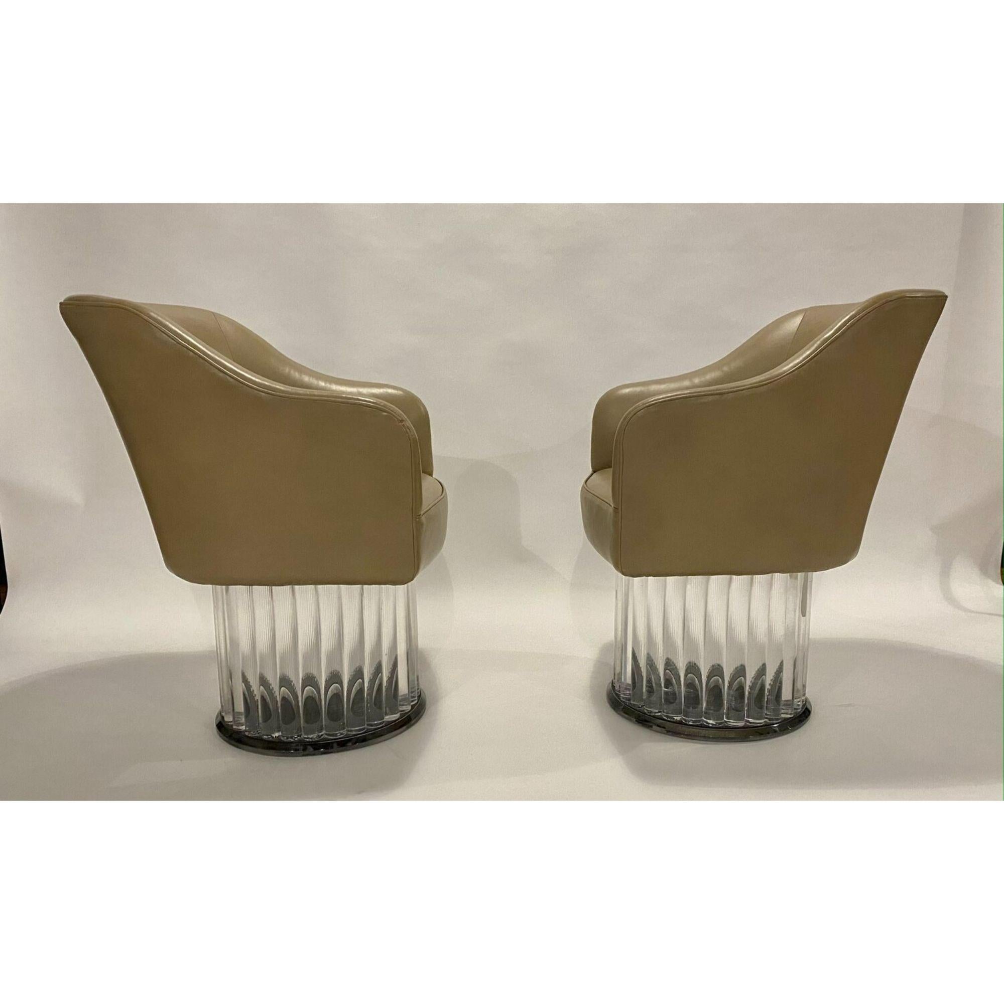 Barrel swivel arm chairs on lucite base in original taupe leather. Listing is for the pair but there is a third chair available. Age appropriate wear on leather and light surface scratches on lucite base..

Materials: Leather, Lucite
Color: