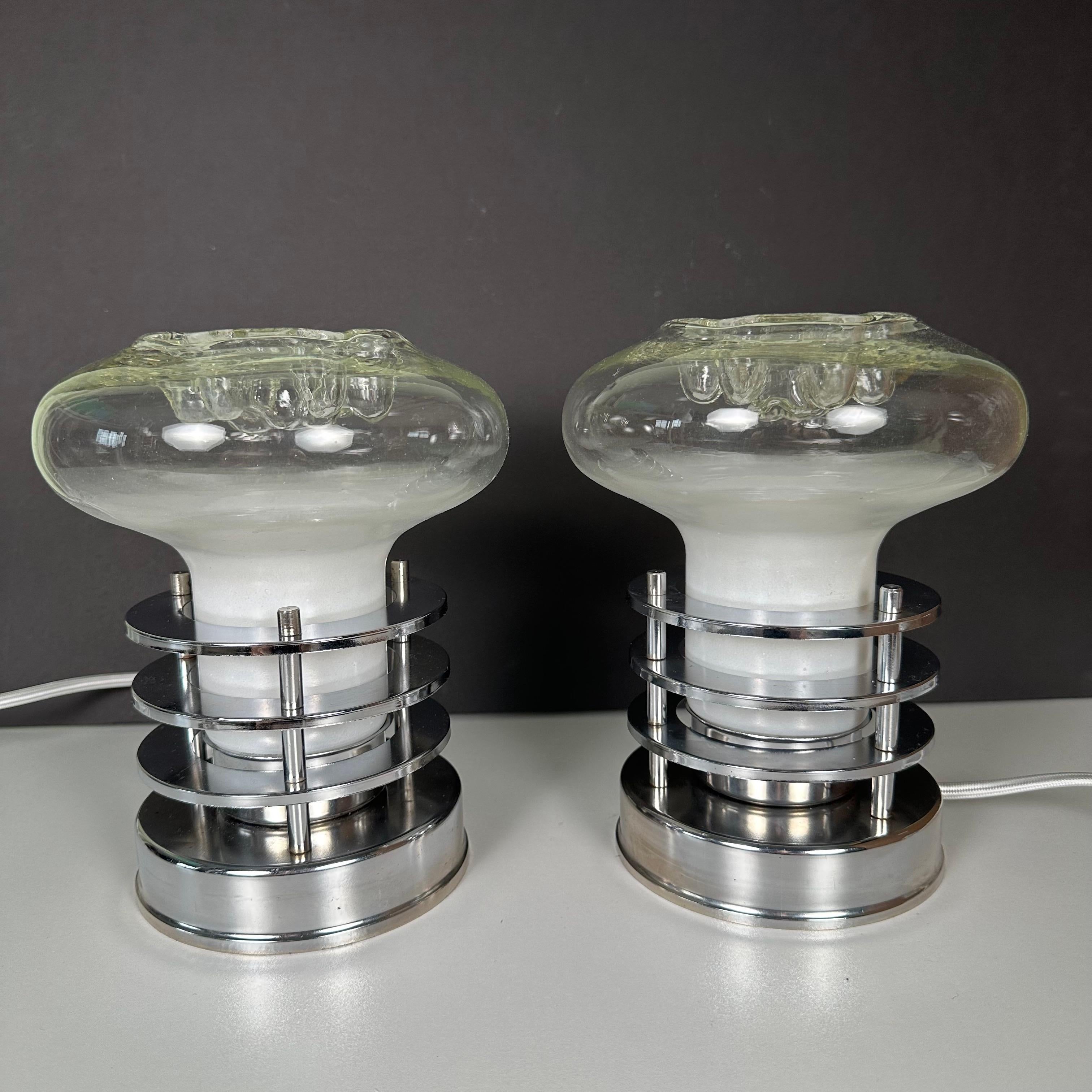 A pair of vintage Space Age table lamps in the style of Toni Zuccheri. A blown glass bulbous, organic mushroom form, indented on top, and with an applied frosted white finish, bubbles over the base, 3 tiers of floating round chrome rings. Made in