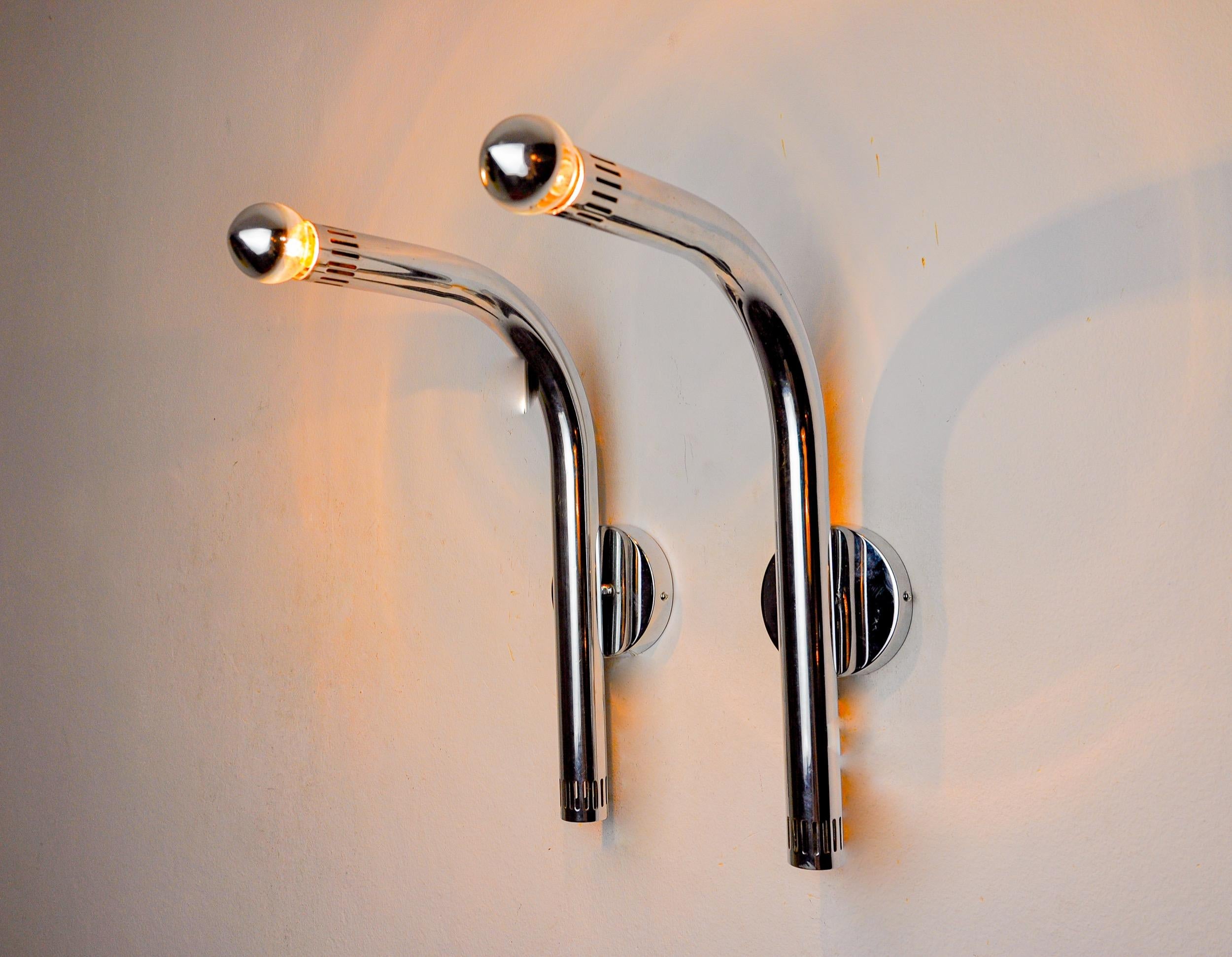 Superba e rara coppia di applique tubolari progettate e prodotte in Italia negli anni '70. Queste applique sono composte da un braccio in metallo cromato che termina con un punto luce a ciascuna estremità. Oggetti dal design unico che illumineranno