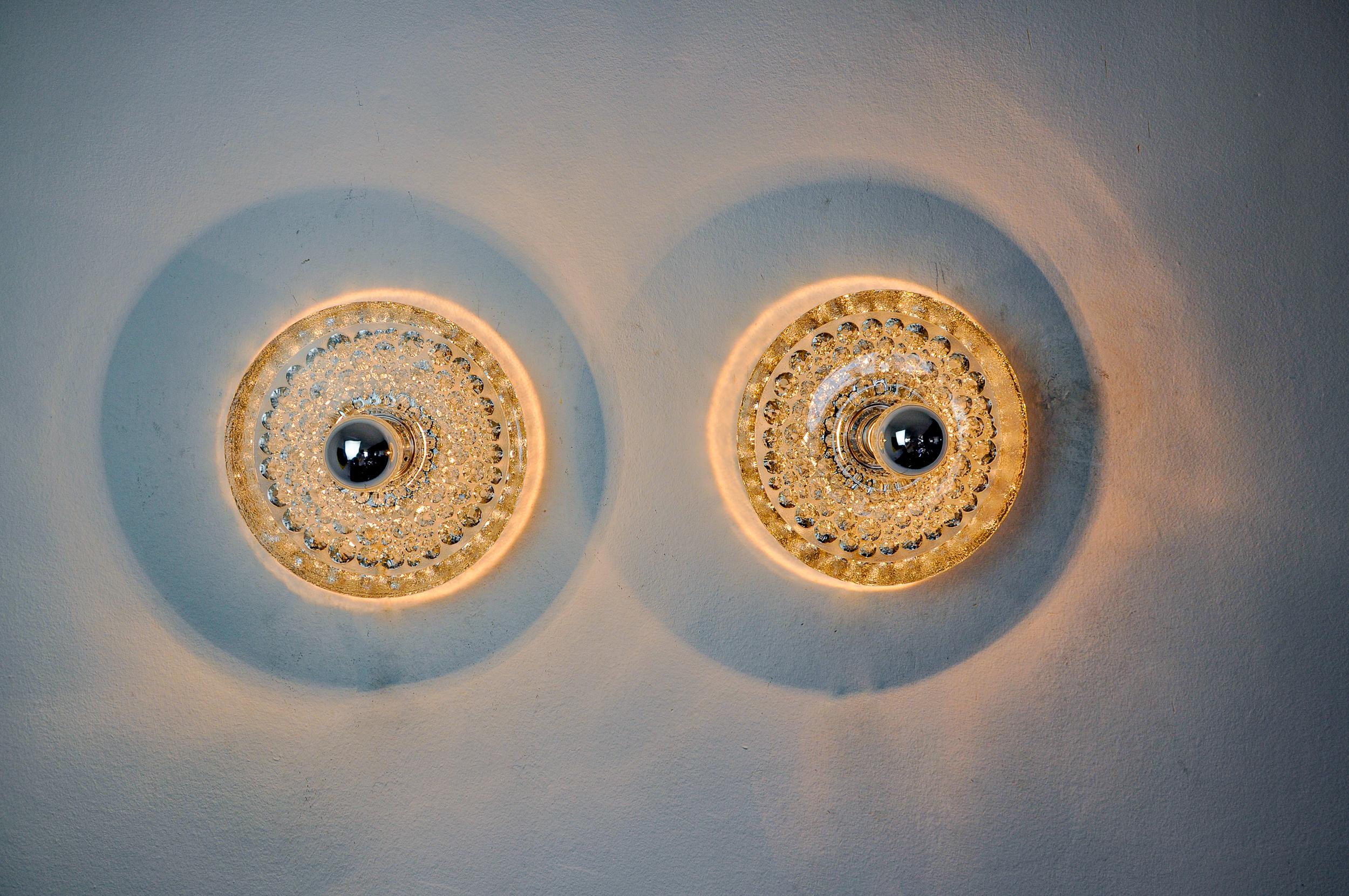 Superb and rare pair of glass sconces designed and produced by Peill and Putzler in Germany in the 1970s. Set of two circular Murano glass sconces supported by a chromed metal base. Magnificent decorative objects that will bring a real design touch