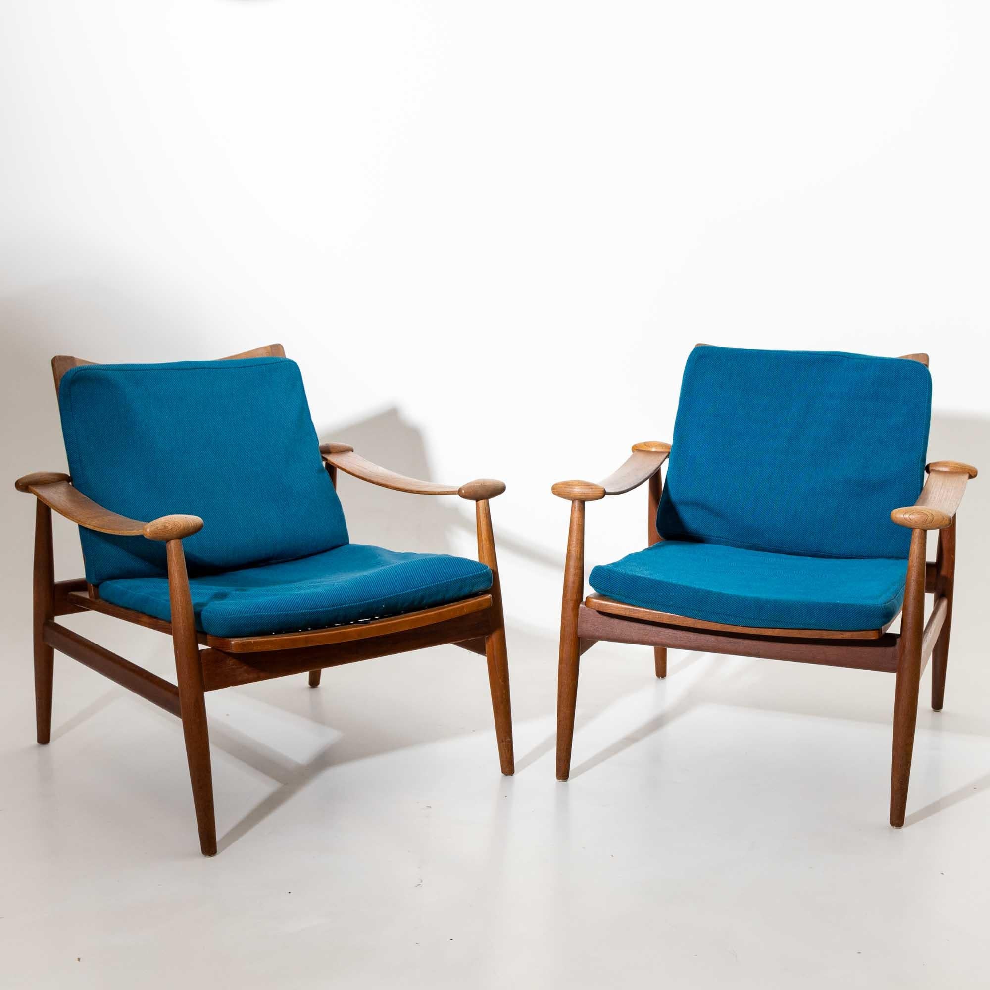 Pair of armchairs of the Spade model, which was designed by Finn Juhl for France & Son in the 1960s. The slightly curved armrests end in the characteristic conical end pieces and give the minimalist frame a special character. The armchairs are in