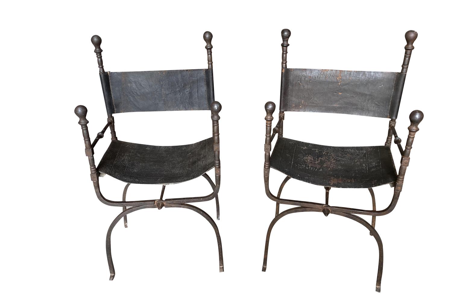 Sensational pair of 18th century armchairs from Spain. Beautifully crafted from hand forged iron and leather. The seat height is 18 1/4