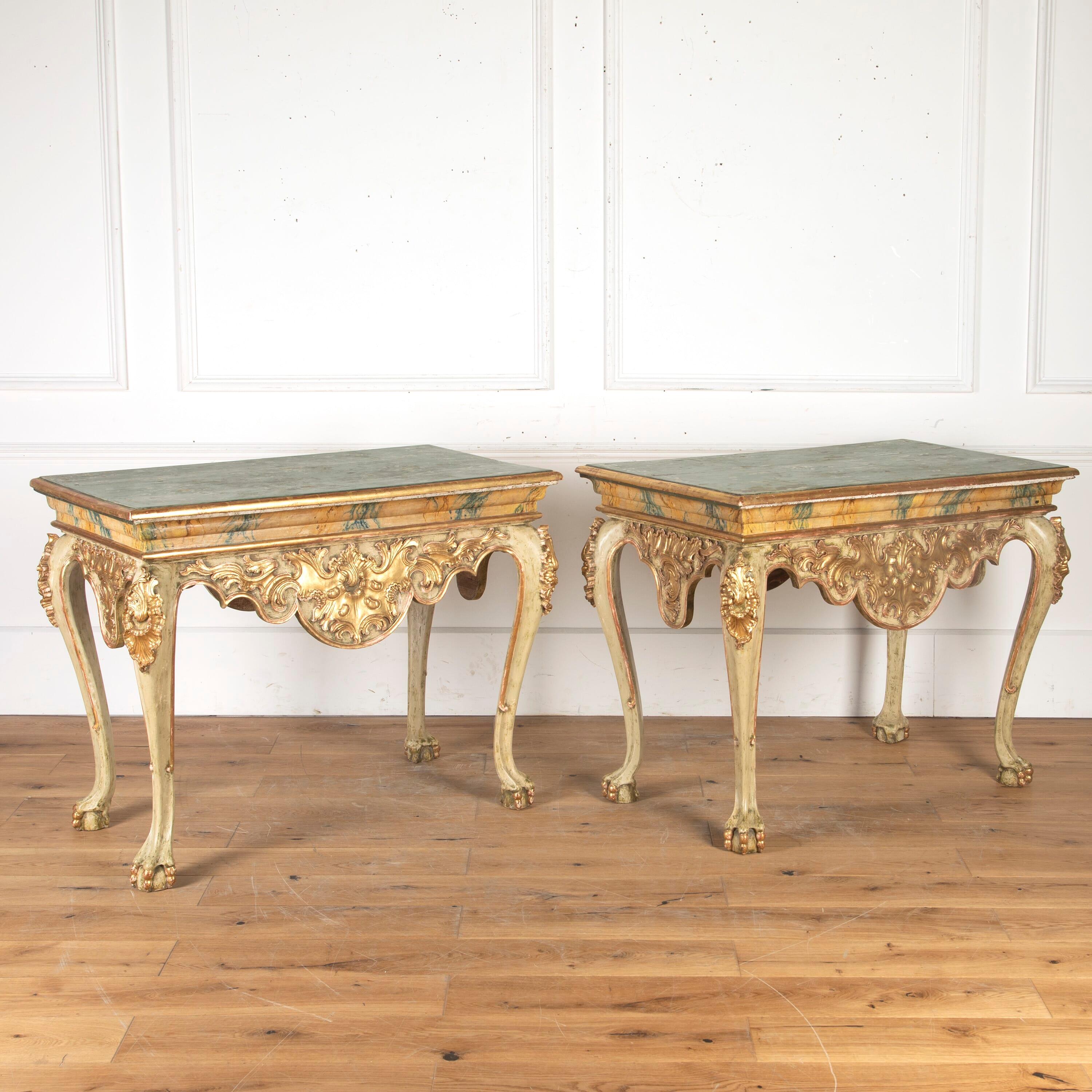 Stunning pair of Spanish 19th century console tables.

This pair feature exceptional carved and painted decoration throughout. The faux marble green top sits above an elaborate dipped frieze with extensive carved acanthus decoration.