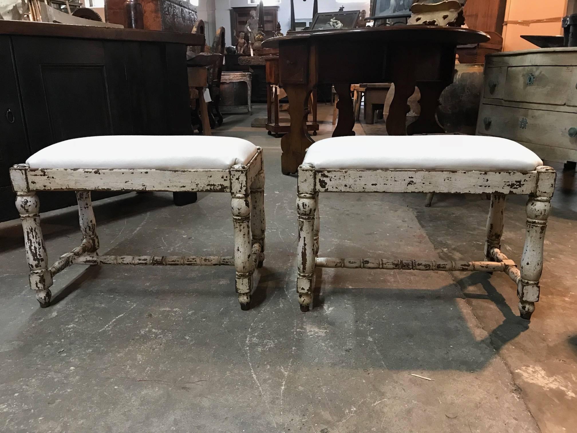 A charming pair of later 19th century benches from the Catalan region of Spain. Beautifully constructed from painted wood with nicely turned legs and stretchers. Recnetly reupholstered.