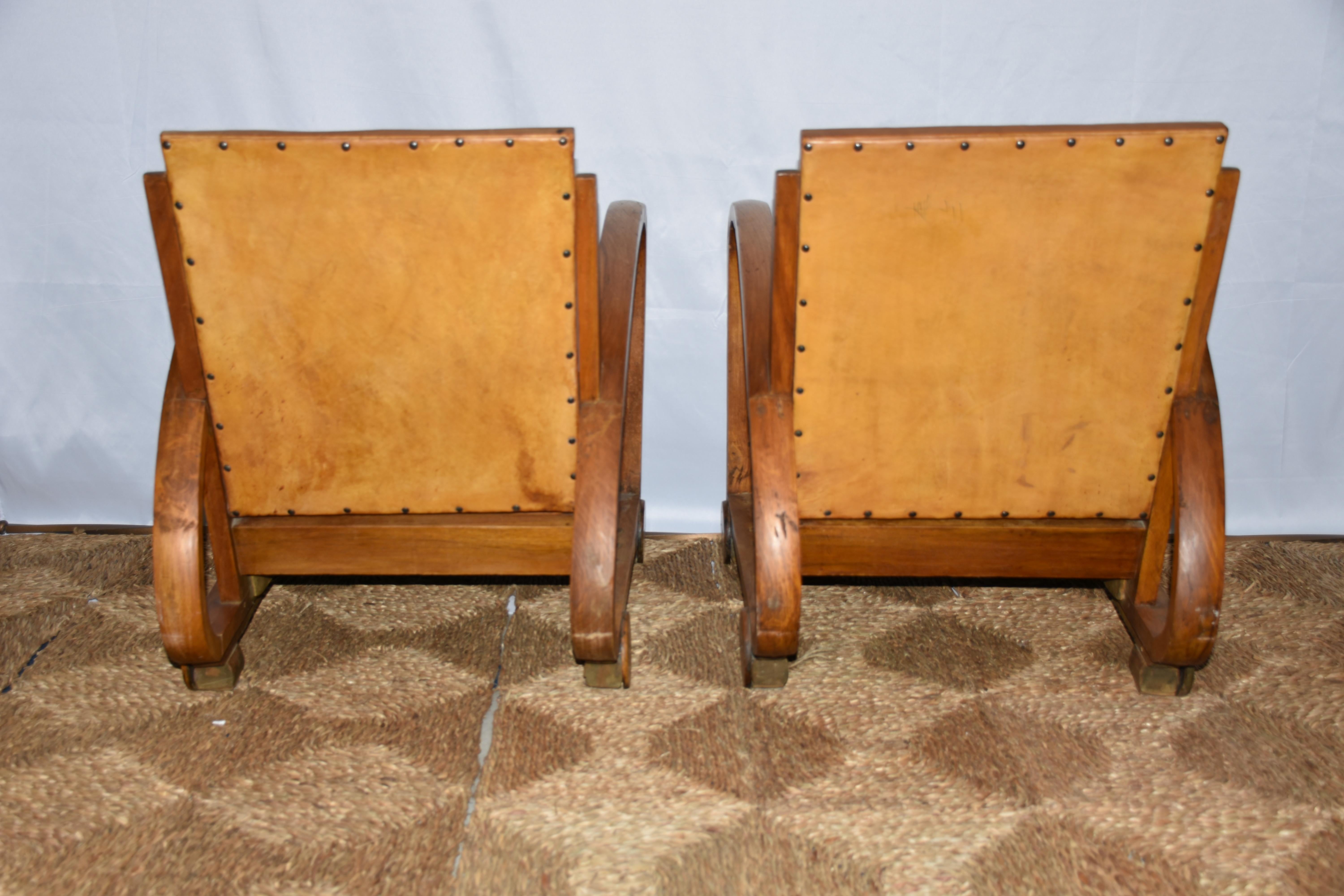 A striking pair of Spanish Art Deco armchairs, circa 1930, crafted from solid wood with beautifully sculpted frames that embody the elegance and geometric restraint of the period. The chairs feature gently curving arms and subtly tapered legs,