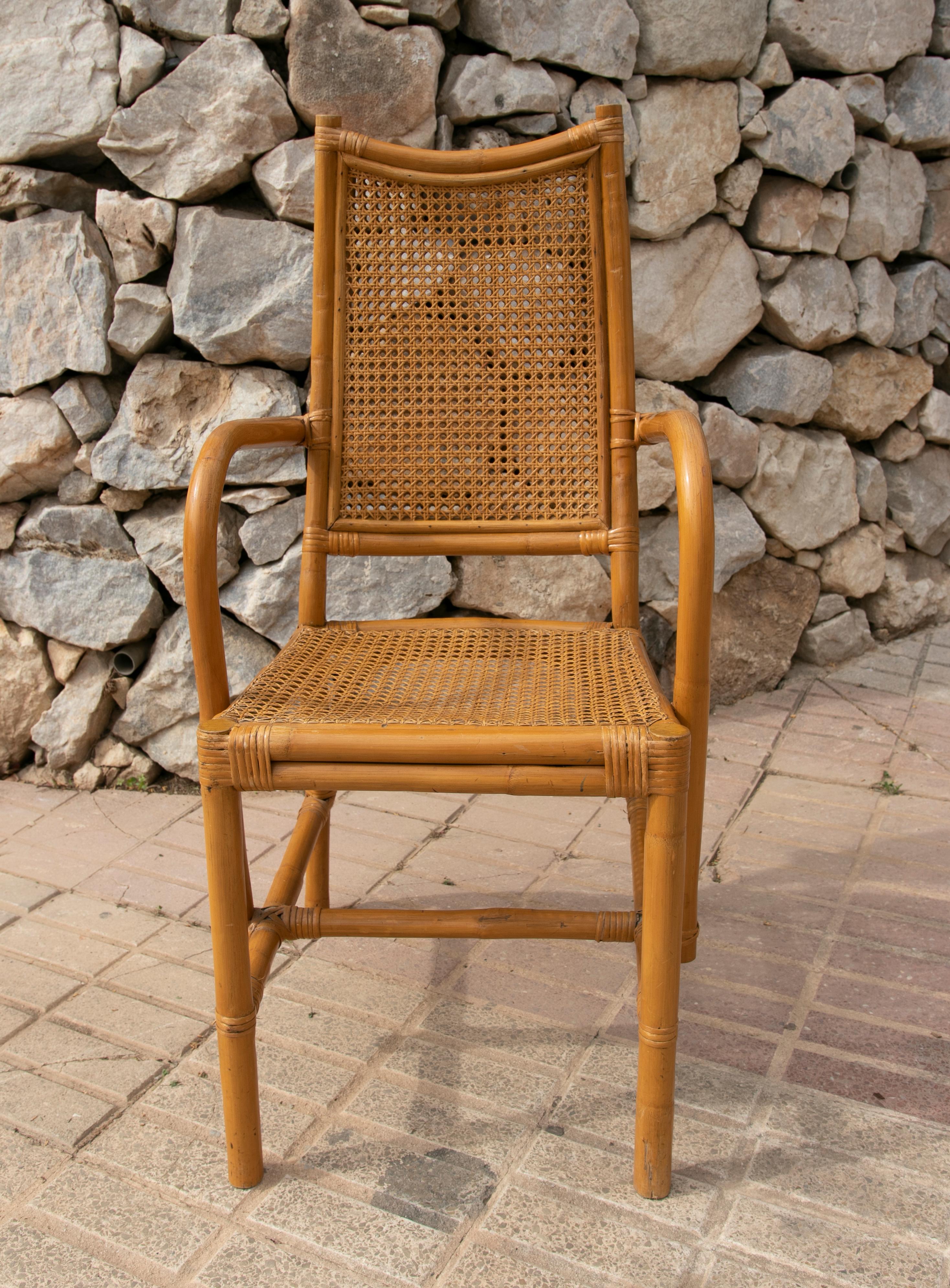 Pair of spanish bamboo armchairs with rattan grid seating and backrest.