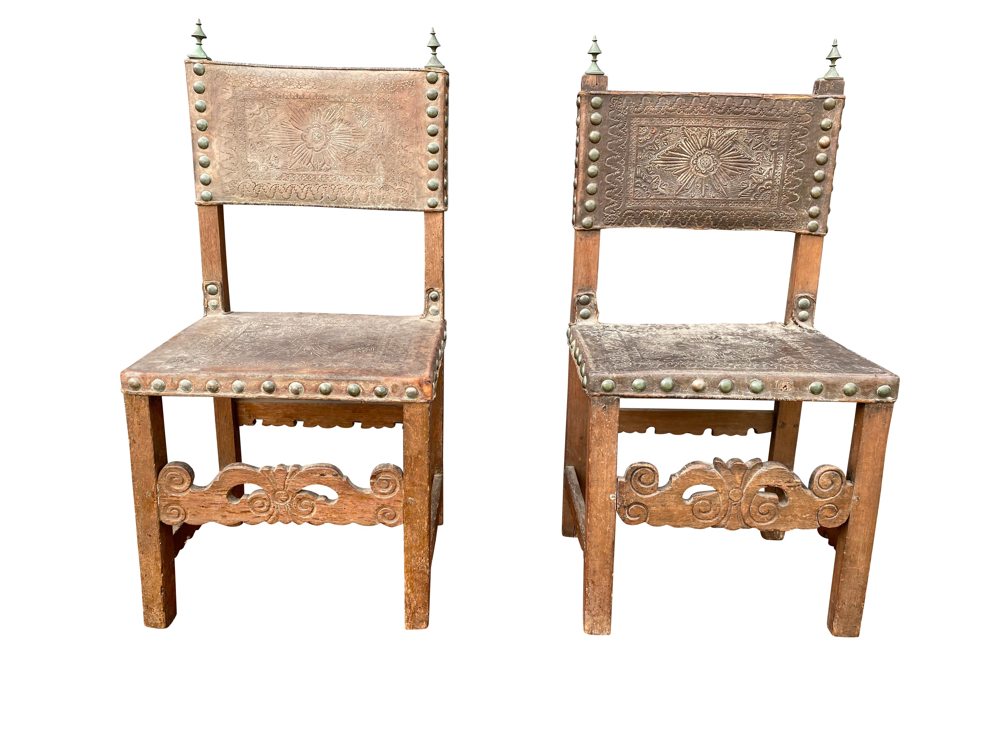 Rectangular leather back and seat with brass studs, square legs with carved stretcher. Brass finials. Provenance William Hodgins.