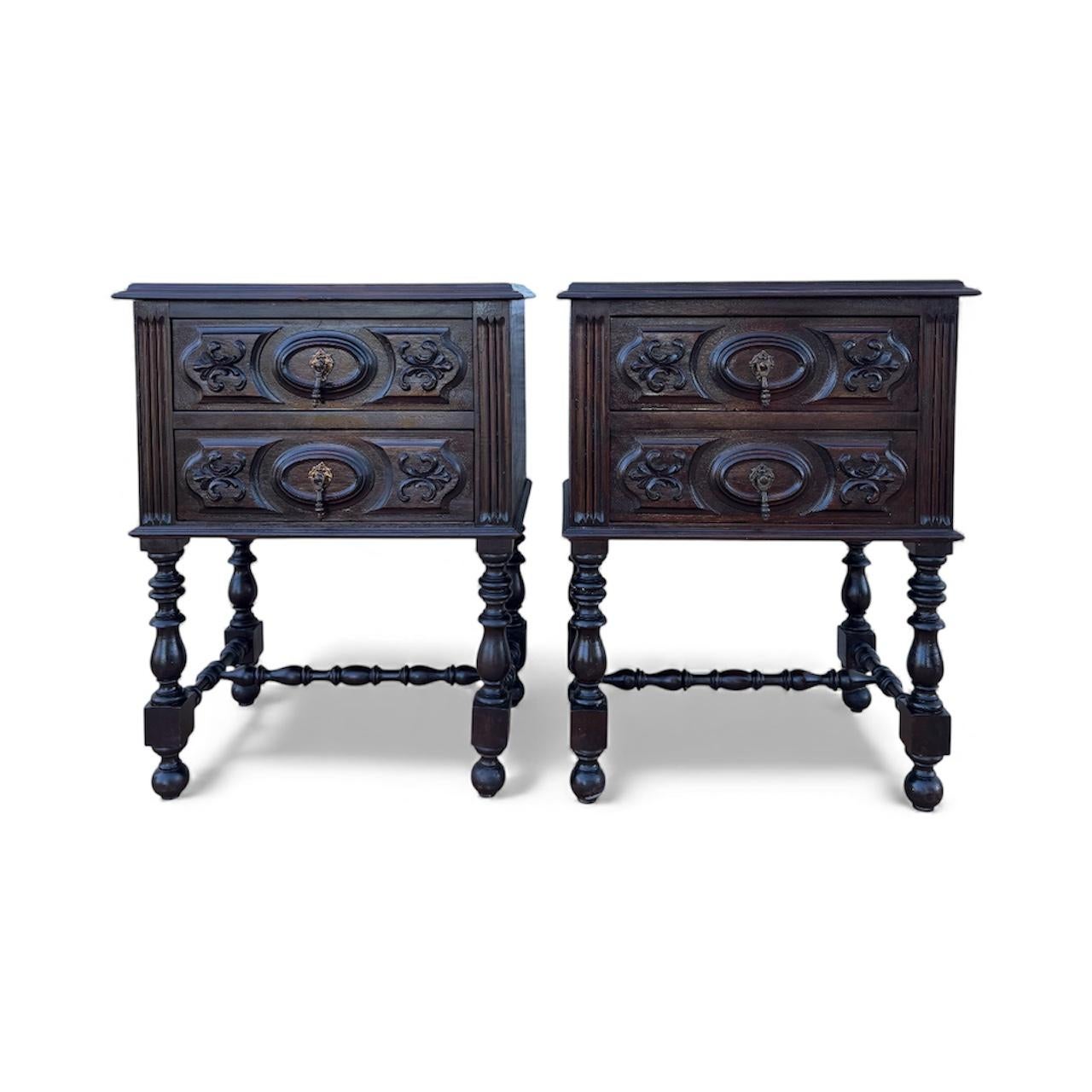 Cette élégante paire de tables de chevet espagnoles date d'environ 1930 et témoigne du savoir-faire raffiné des meubles néo-Renaissance du début du XXe siècle. Chaque pièce est fabriquée en chêne massif teinté foncé et comporte deux tiroirs sculptés