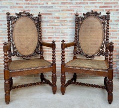 Paire de fauteuils espagnols en bois sculpté avec assise et dossier en rotin, années 1920