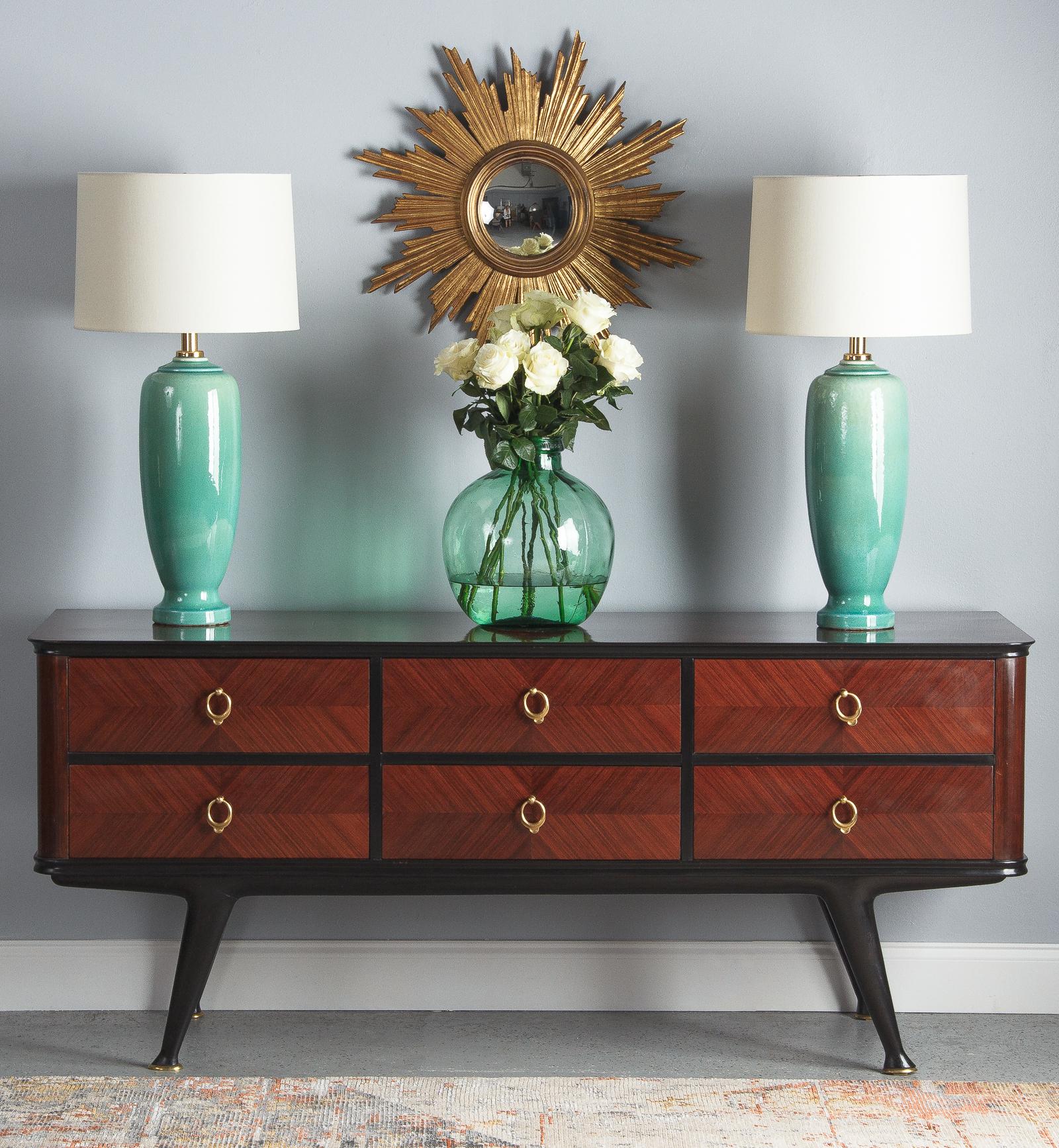 Pair of glazed ceramic lamps by Acanto Division, Valencia, Spain, circa 1960. Glazed in a light blue-green with a fine crackle finish. The lamps are tall with subtle molding at the top and a slight taper near the base. Brass fixtures contrast nicely