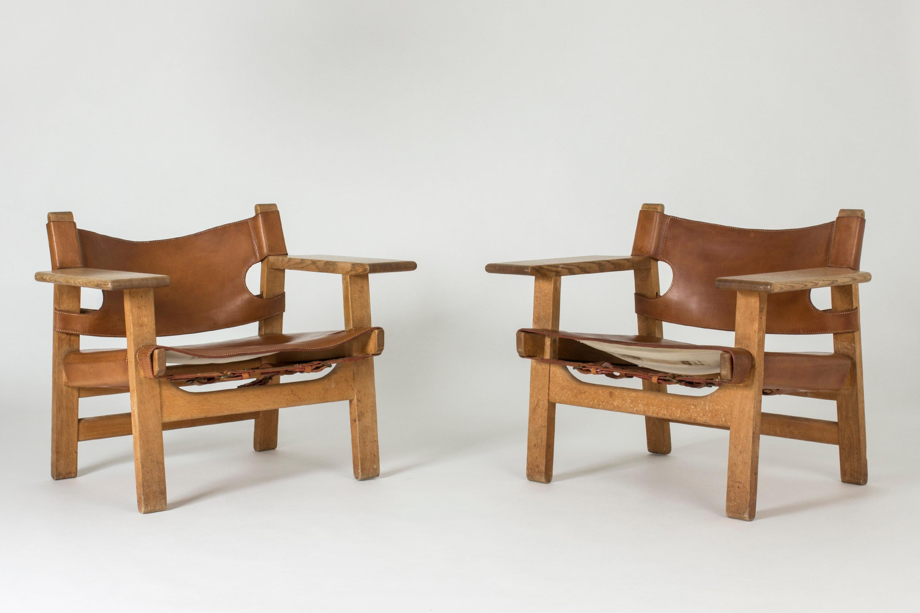 Pair of iconic oak and cognac leather “Spanish Chair” lounge chairs by Børge Mogensen. Mogensen got his inspiration for this design from a trip to Spain in 1958, where he came across a type of traditional chair which he then interpreted in a