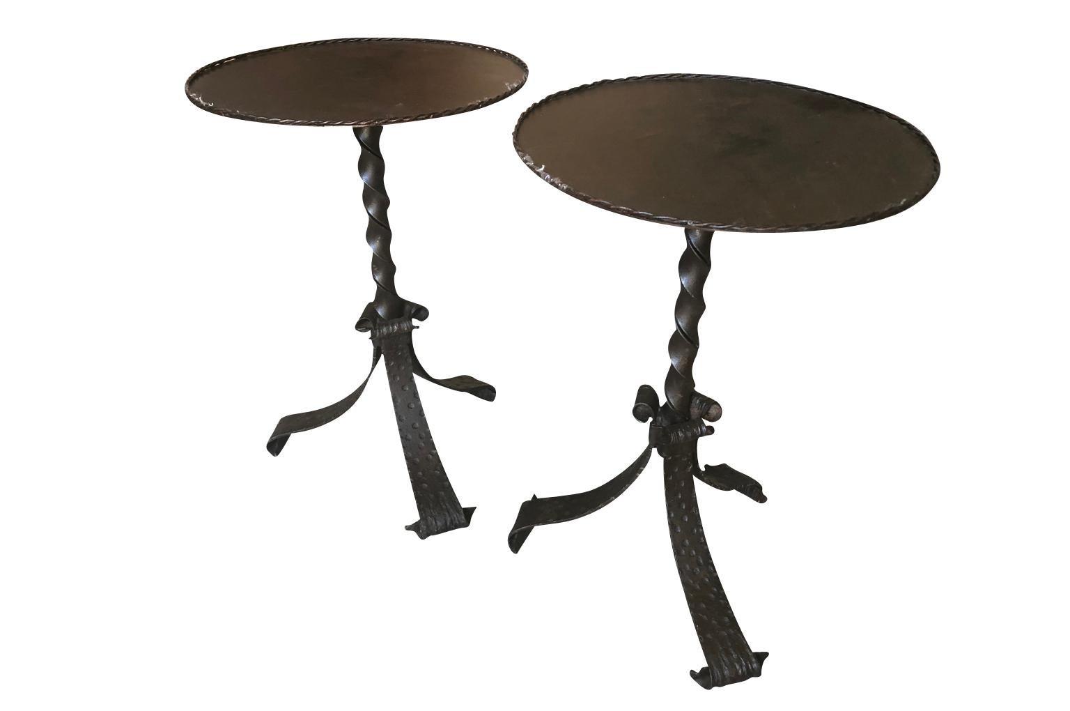 A terrific pair of iron cocktail tables created from Spanish mid-19th century iron bases from torcheres or lamps. Perfect drinks tables or smaller end tables. Great patina.