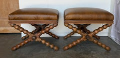 Coppia di sgabelli in stile barocco coloniale spagnolo con base a X e piedini a bobina, rivestiti in pelle invecchiata