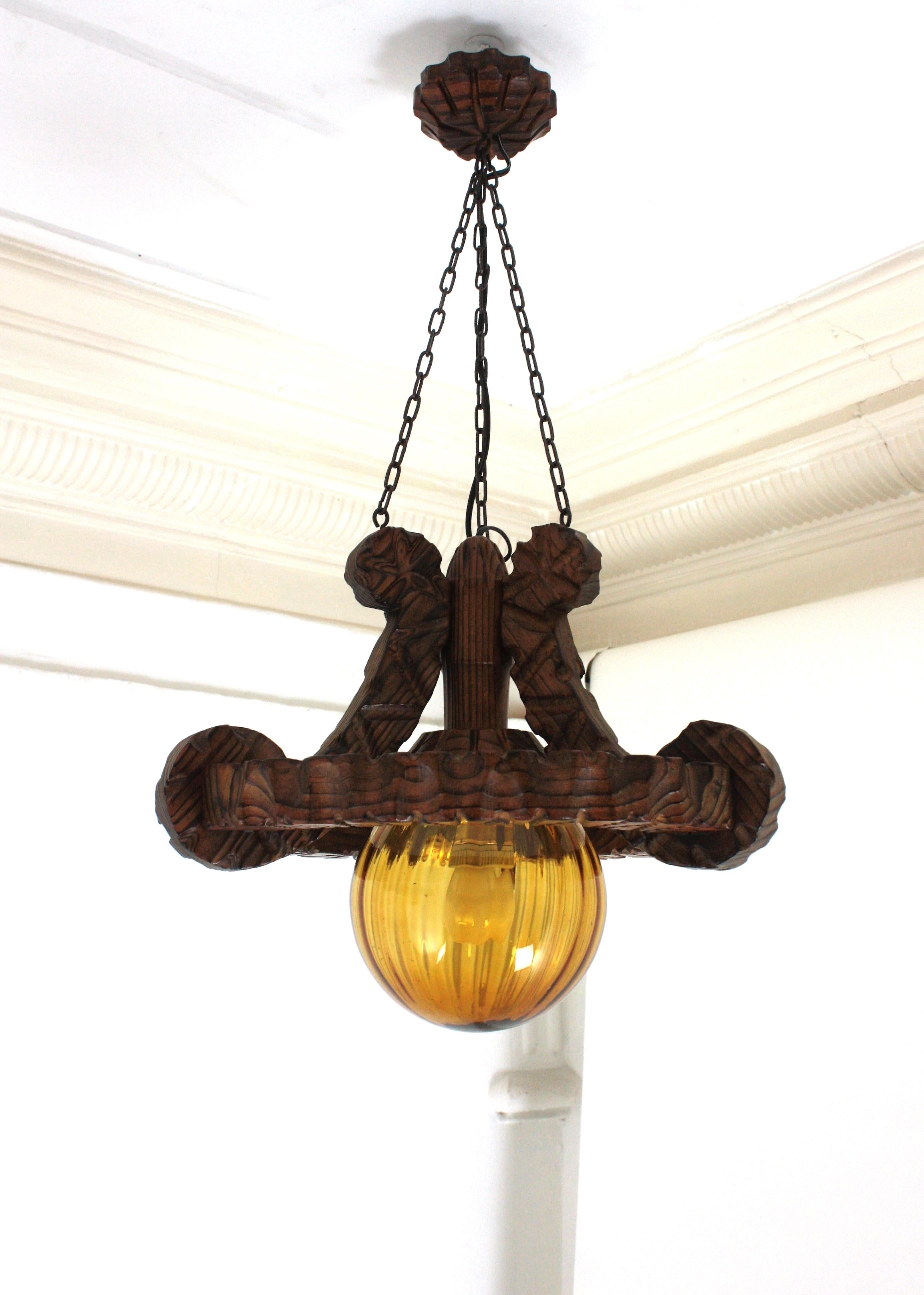 Pair of Spanish Colonial Pendants / Light Fixtures in Carved Wood & Amber Glass In Good Condition For Sale In Barcelona, ES