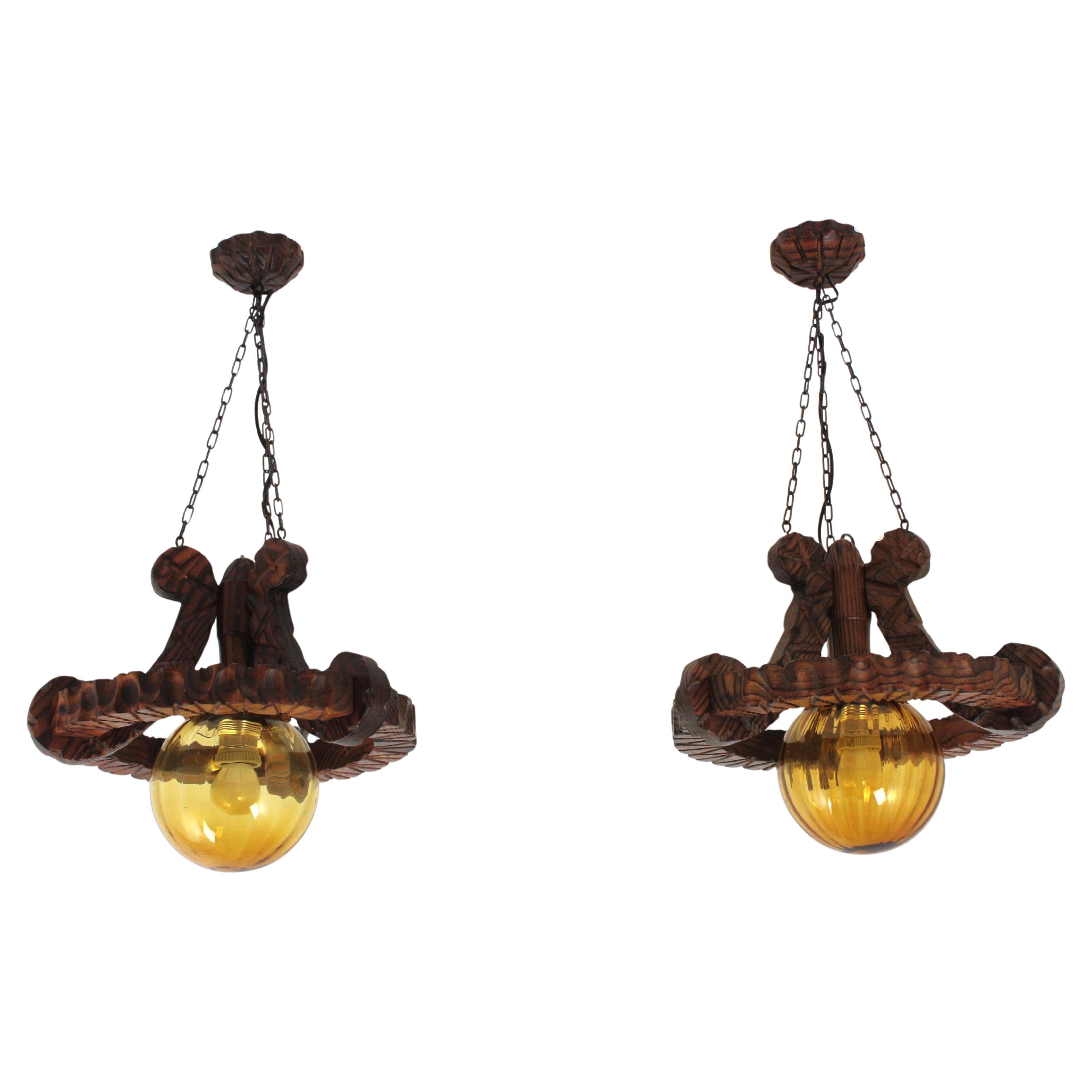 Pair of Spanish Colonial Pendants / Light Fixtures in Carved Wood & Amber Glass For Sale