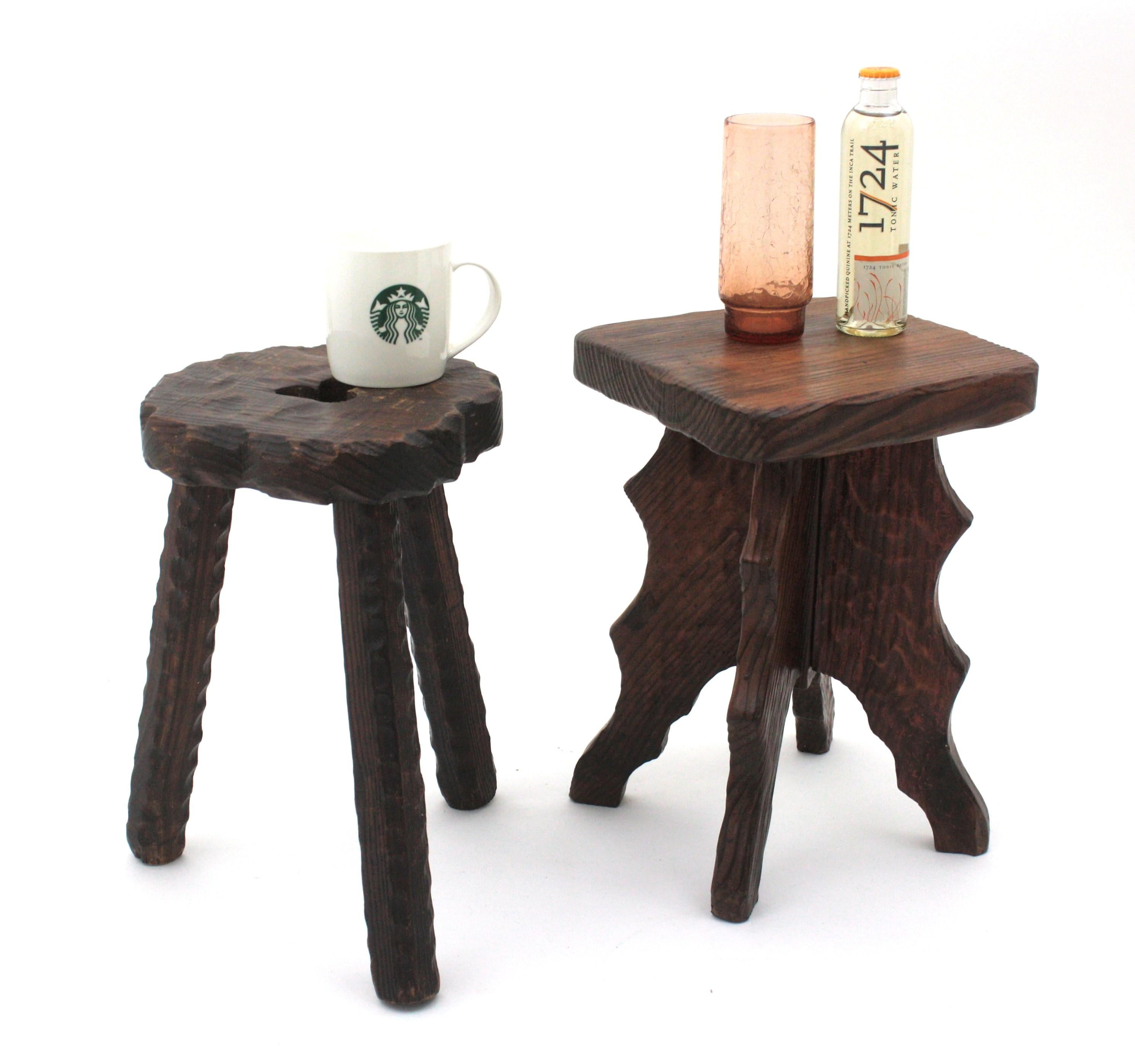 Pair of Carved Wood Stools or Small Side Tables, Spain, 1940s
Eye-catching unmatching pair of Spanish Revival wooden stools.
One with squared top and four legs with scalloped details.
The tripod one has scalloped carving accents on the top and a 3