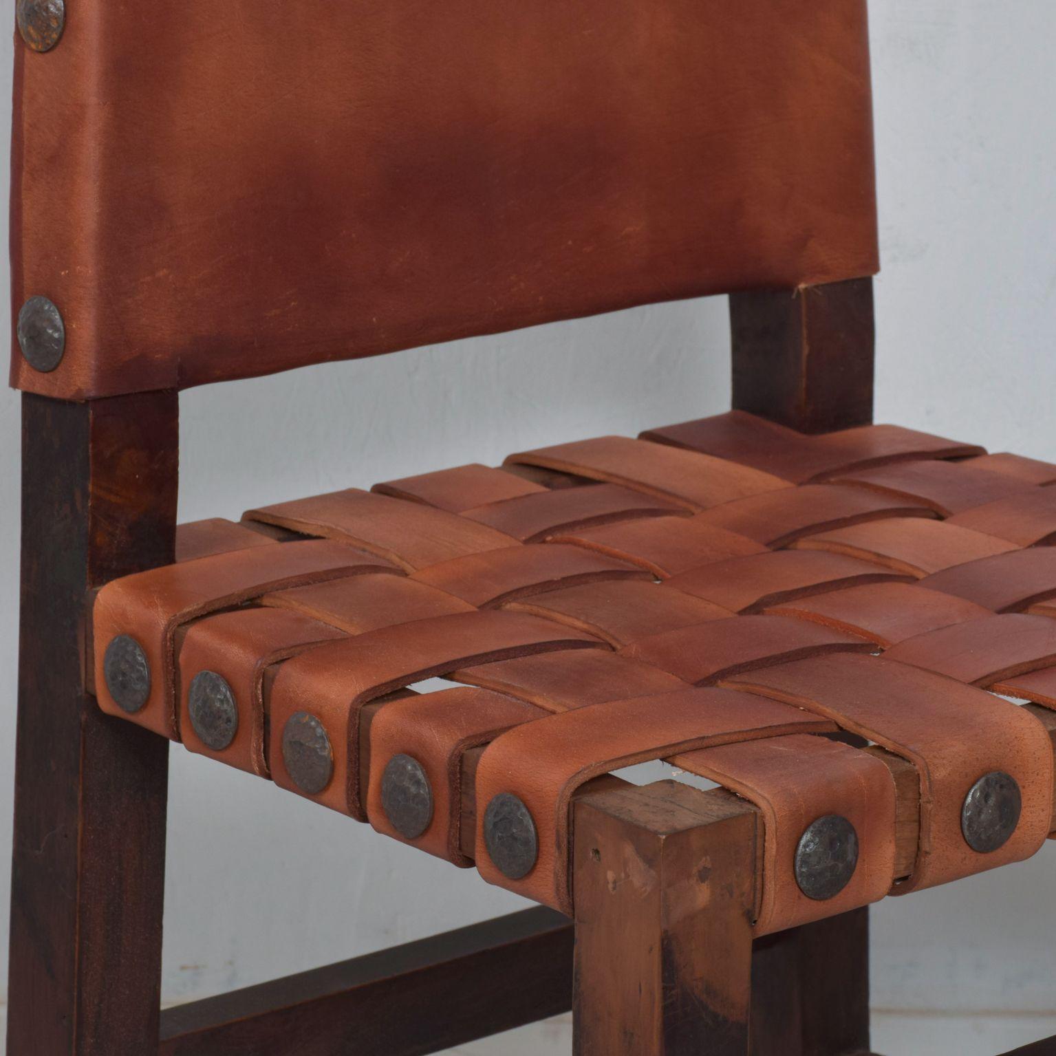 For your consideration: A pair of Spanish Colonial Wood Chairs. Featuring new saddle leather. Made in Mexico circa 1950s.

Heavy woven strap leather seats with nail head accent.

In the manner of Clara Porset and Luis Barragan. No signature
