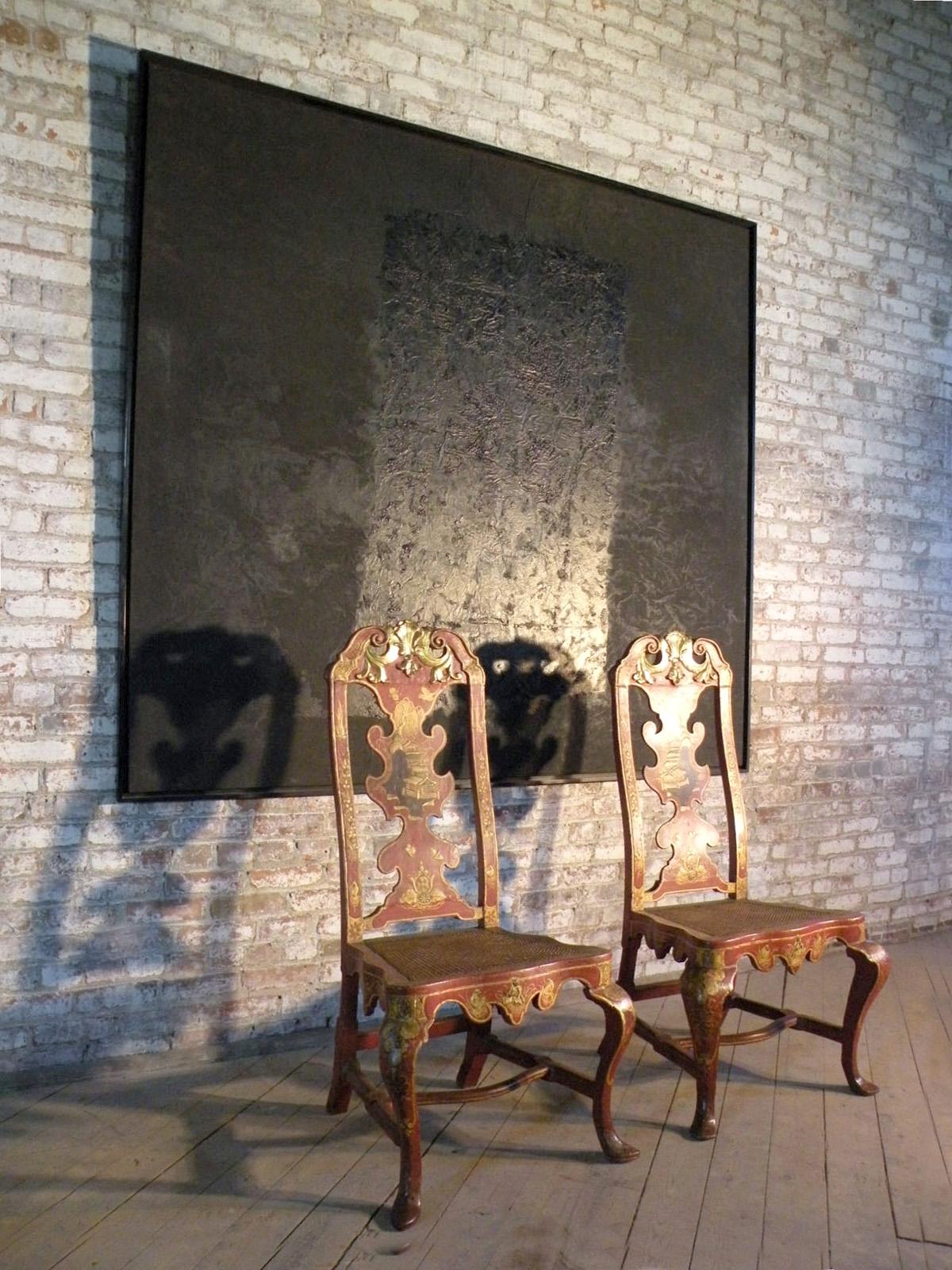 A pair of Spanish early 18th century red lacquer chinoiserie decorated side chairs in the English taste, manner of Giles Grendey. The shaped backs in between straight uprights, topped by a scrolling crest, shaped seats with fine caning, and