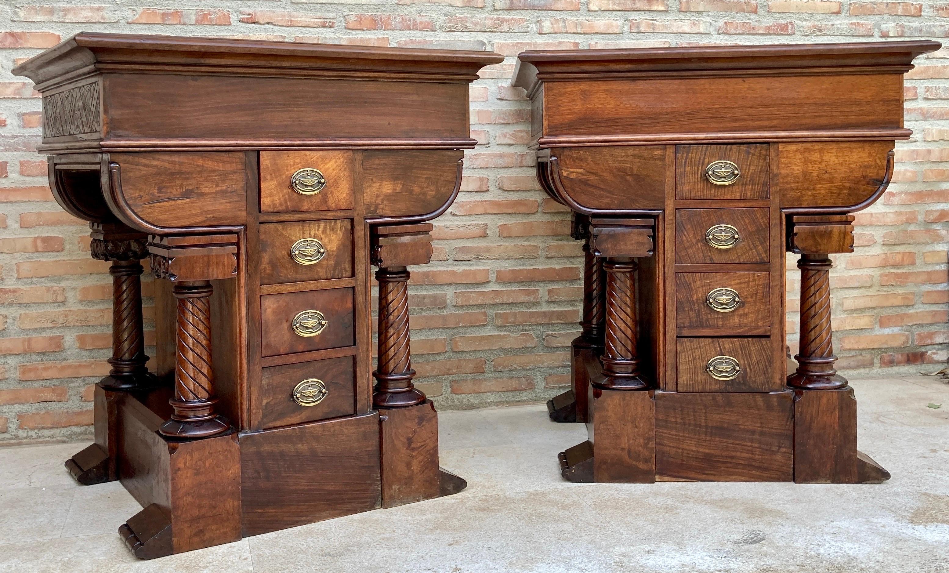 Exceptional pair of Spanish Empire Revival nightstands dating from the late 19th century. Each piece features a central stack of four drawers framed by sculptural spiral-turned columns and supported by solid plinth bases. The richly figured wood