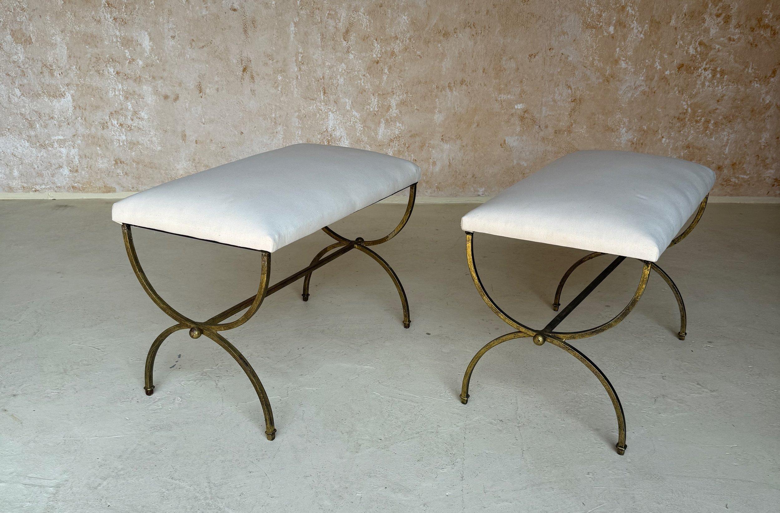 This elegant pair of recently made Spanish gilt iron benches features gracefully curved legs and central stretchers with decorative central ring details and spheres at the ends. Handmade by expert European craftsmen, this lovely pair of benches have