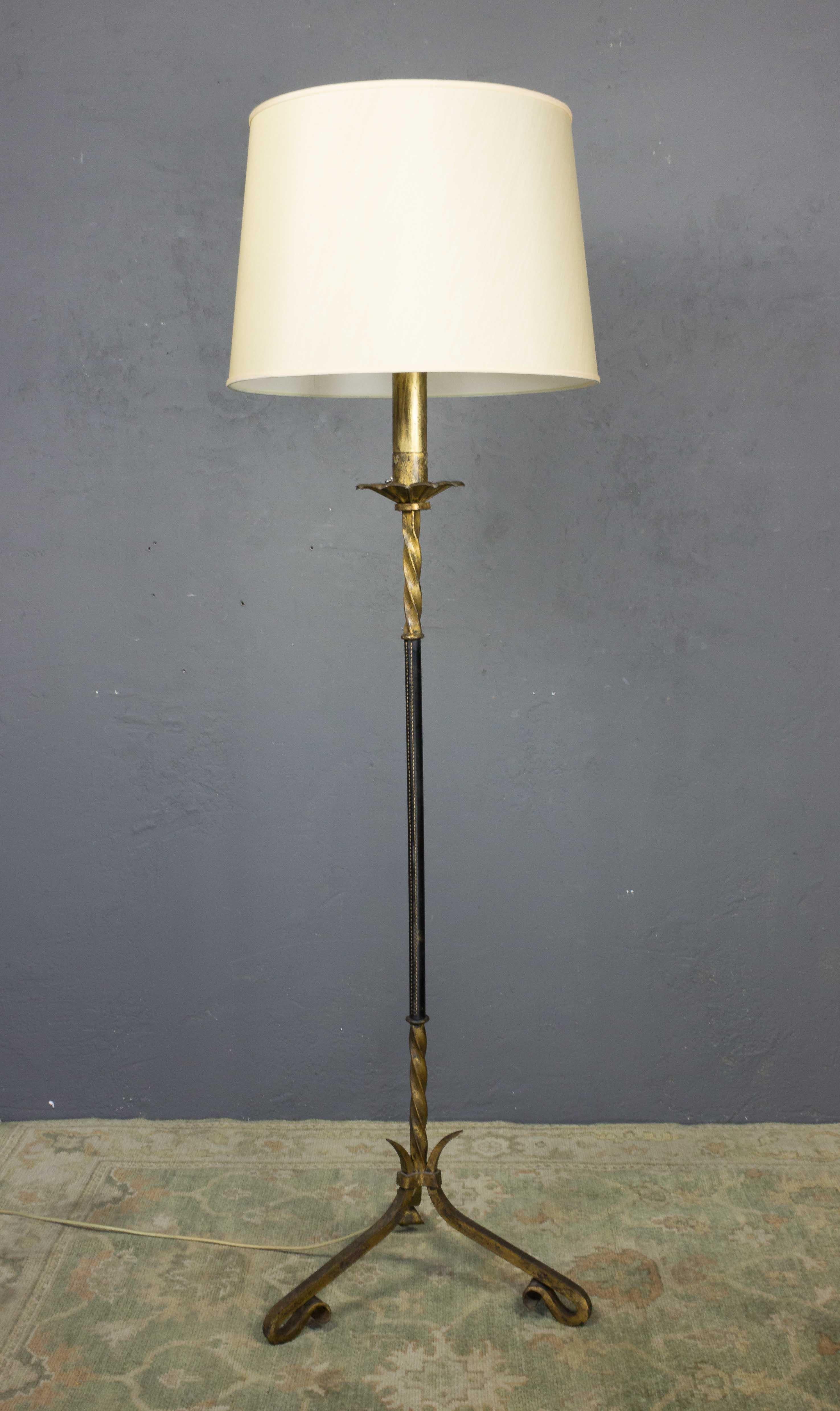 A pair of gilt iron floor lamps with a wrapped leather stems. Shades not included, Spanish, 1950s.