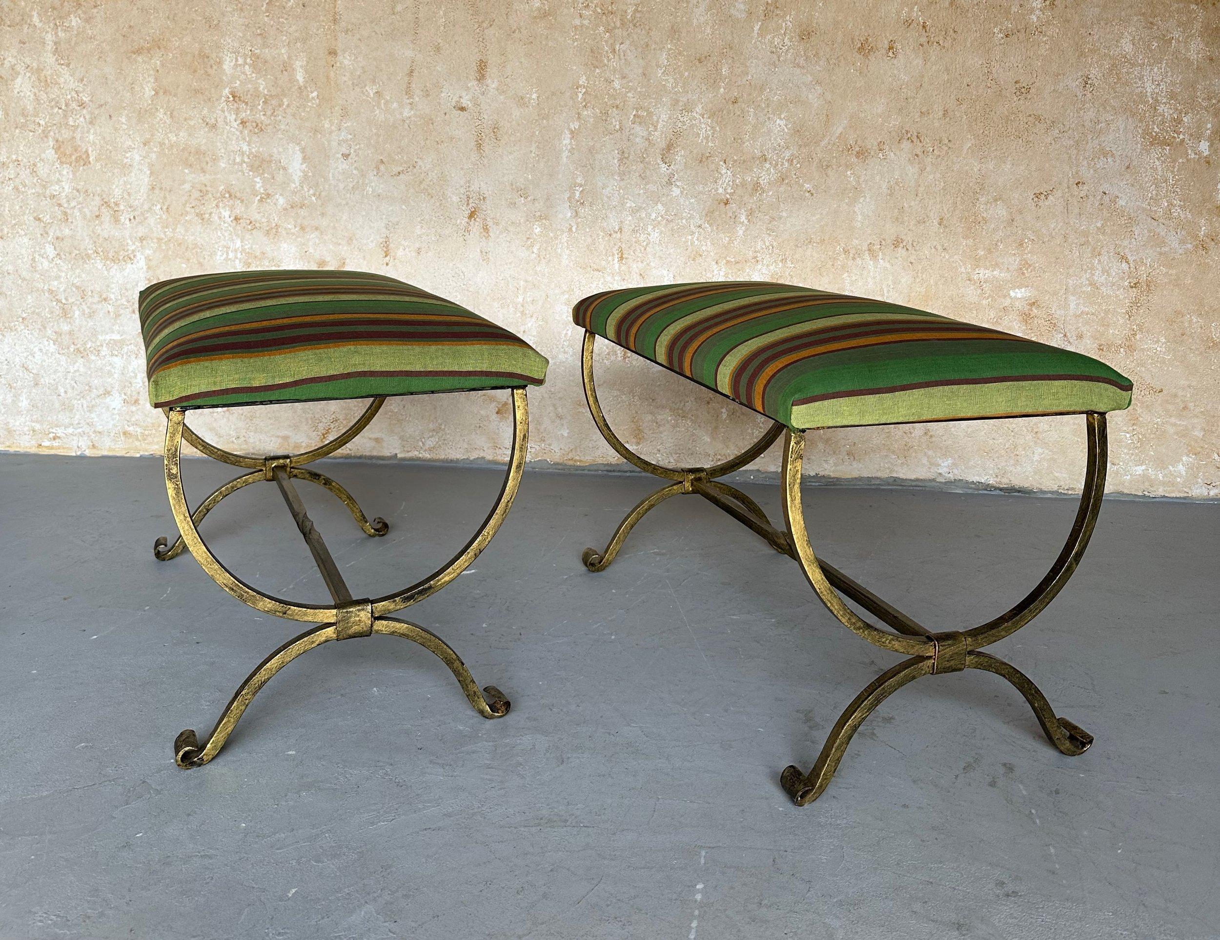 Estos elegantes bancos españoles de hierro dorado han sido fabricados recientemente a mano por hábiles artesanos europeos mediante técnicas tradicionales de trabajo del hierro. Presentan patas y camillas con gráciles volutas y decorativos giros