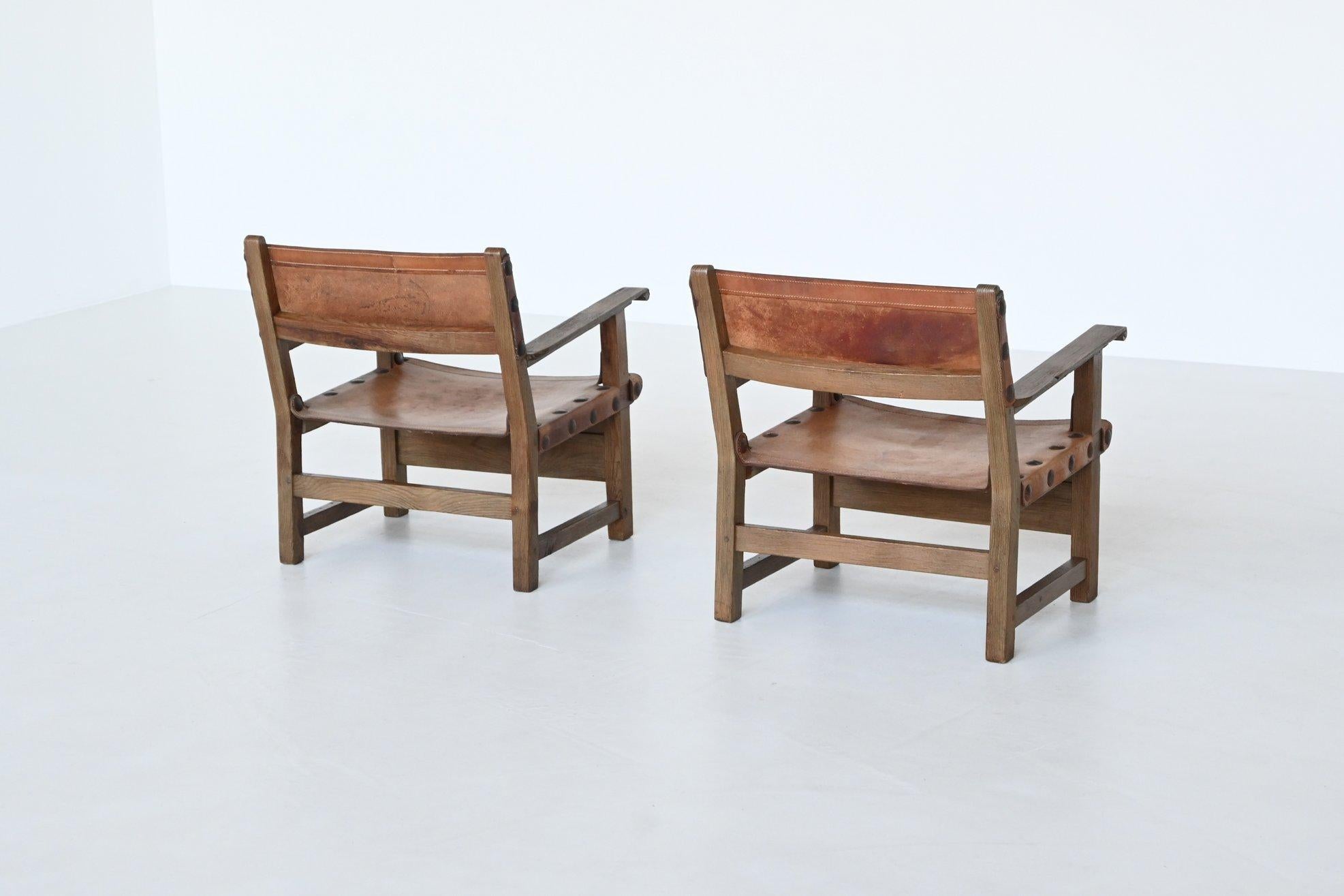 Leather Pair of Spanish lounge chairs oak and saddle leather Spain 1960 For Sale