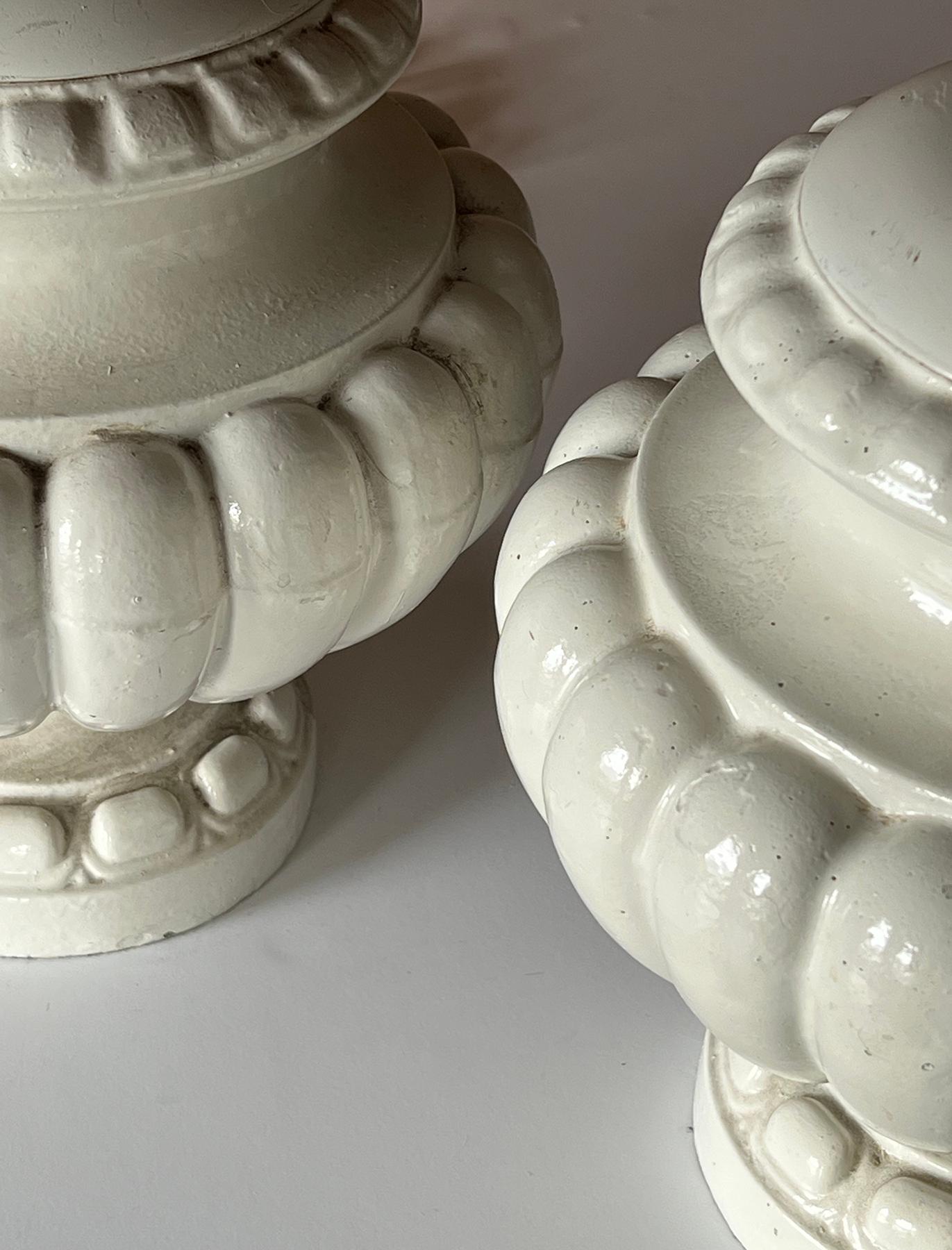 chaque lampe portative avec un col évasé au-dessus d'un corps lobé comprimé, le tout sur une base circulaire évasée ; avec une surface émaillée ivoire et des capuchons en bois assortis