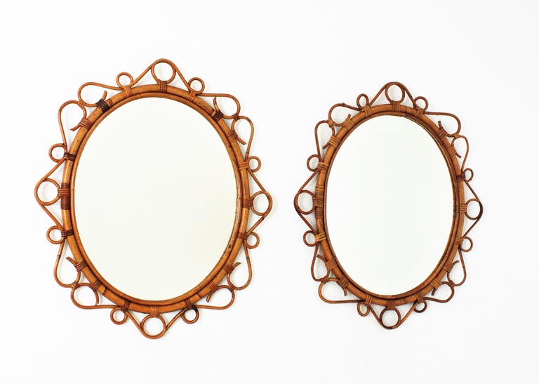 A pair of eye-catching handcrafted bamboo and rattan oval mirrors with scroll detailing surrounding the frame. Spain, circa 1960s.
These Mediterranean wall mirrors feature an oval bamboo frame surrounded by rattan scroll and circle