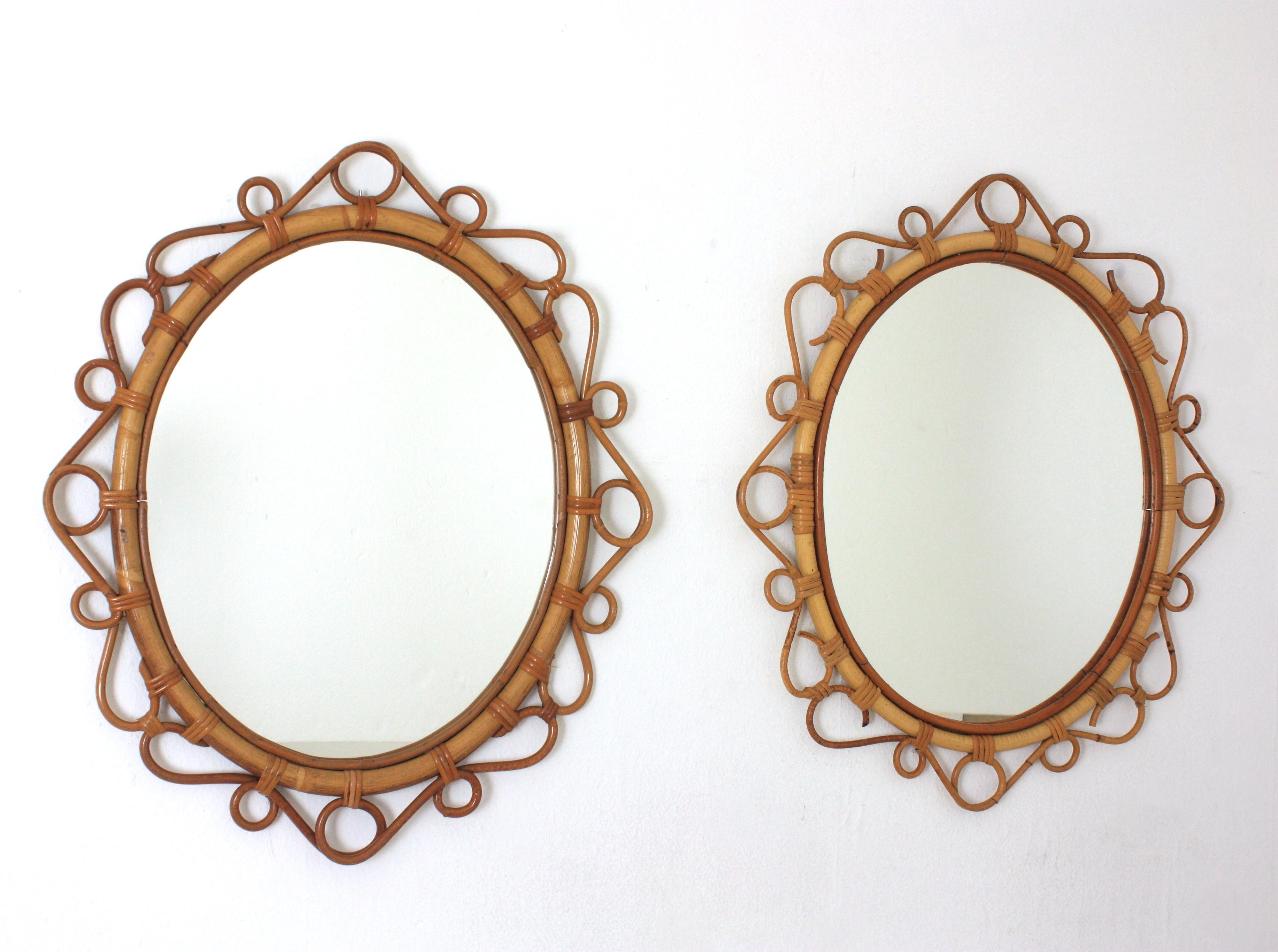 A pair of eye-catching handcrafted bamboo and rattan oval mirrors with scroll detailing surrounding the frame. Spain, circa 1960s.
These Mediterranean wall mirrors feature an oval bamboo frame surrounded by rattan scroll and circle decorations.
They