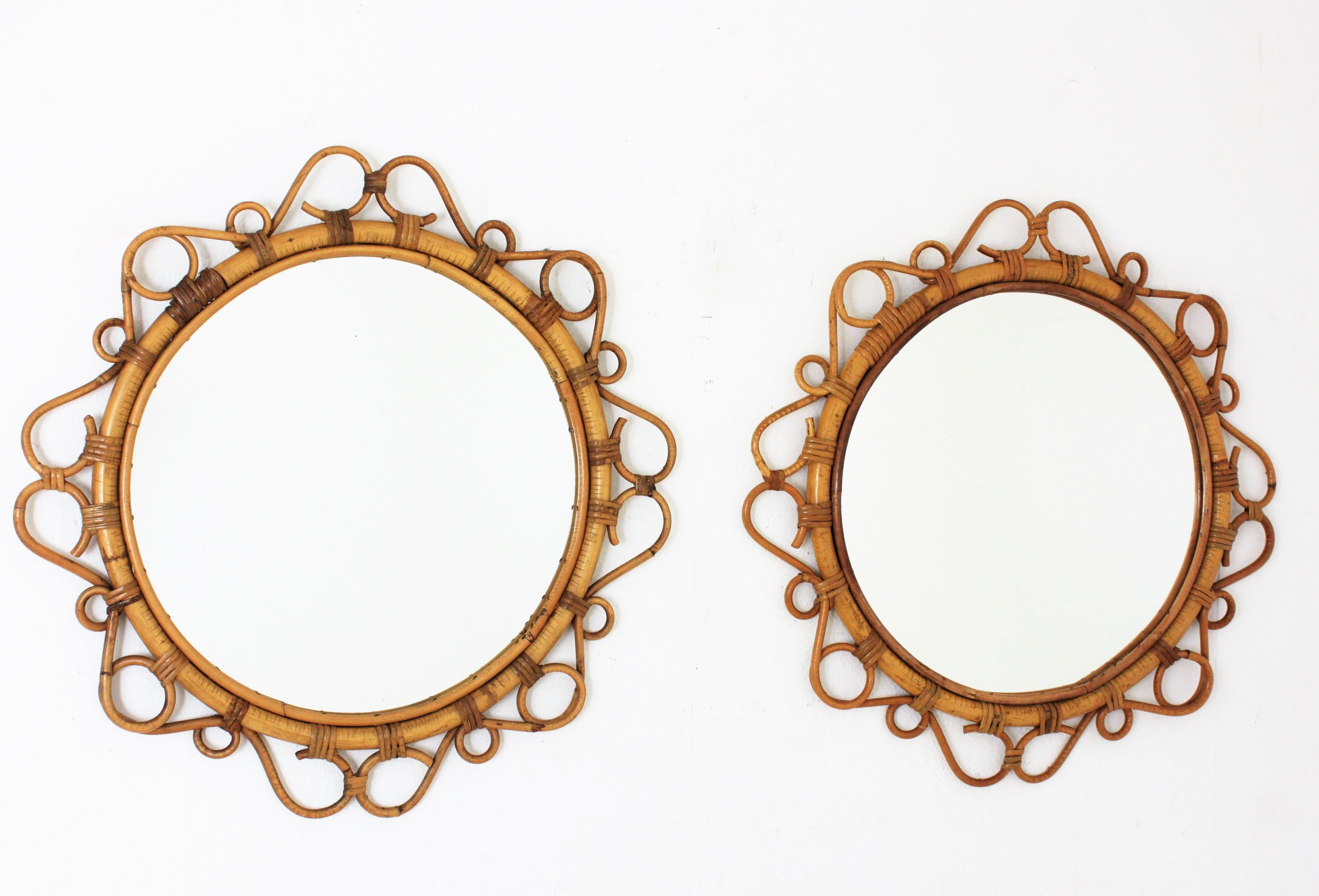 A pair of eye-catching handcrafted bamboo and rattan mirrors with scroll detailings surrounding the frame, Spain, 1960s. 
These Mediterranean wall mirrors feature a circular bamboo frame surrounded by rattan scroll and circle decorations.
They