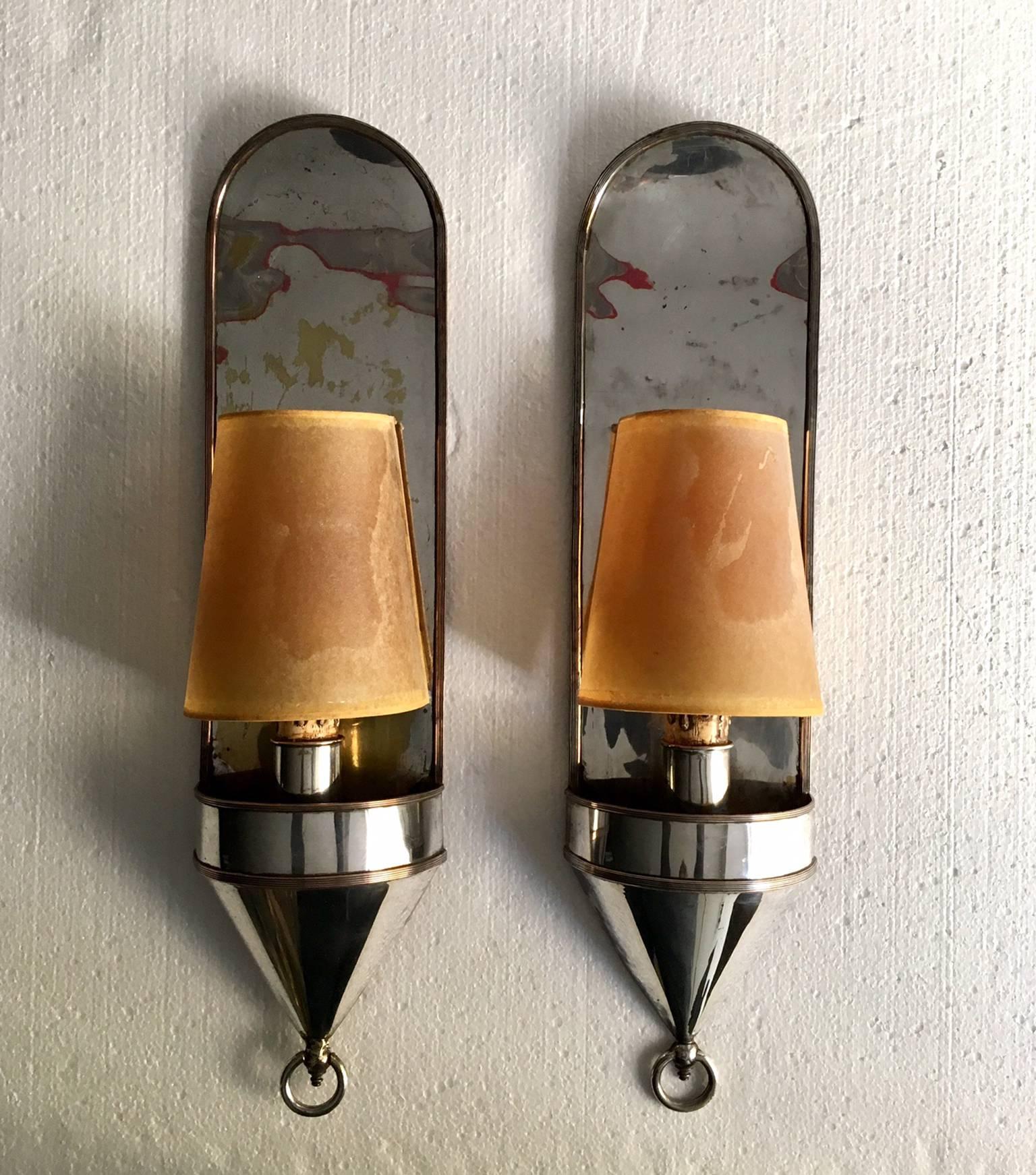 Pair of large silver metal sconces, the base is a cubic container finished in a metal ring, they have a nice patinaThe wall lights include their original lampshades and new ones that we have made, as you can see in the photo.
Signed in the area of