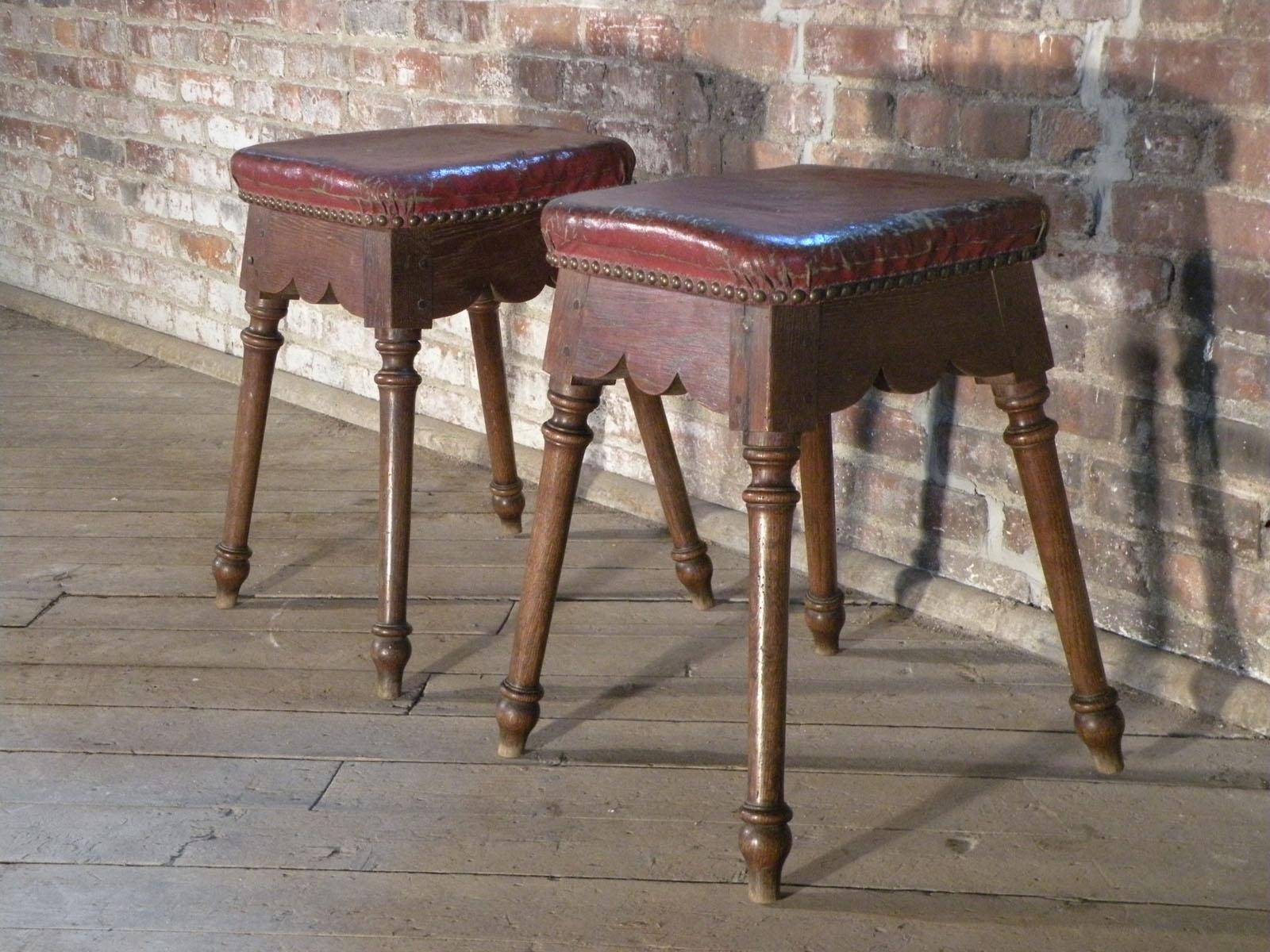 Coppia di sgabelli quadrati imbottiti spagnoli in rovere barocco dal design e dalle proporzioni uniche. Il sedile imbottito sovrasta un grembiule a forma di onda, che si unisce alle gambe a colonna strombate in quattro direzioni, che terminano con