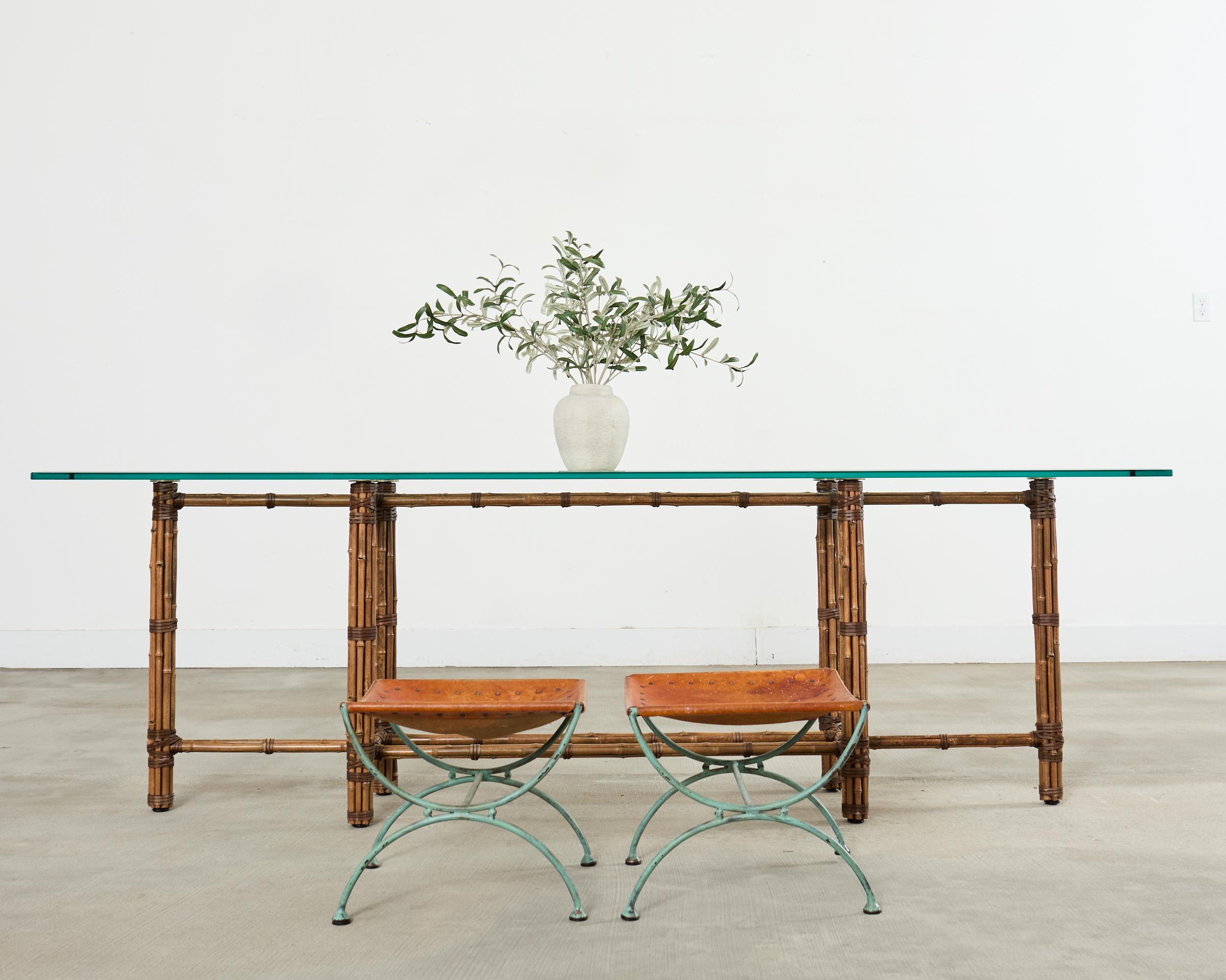 Gorgeous pair of mid-century modern wrought iron stools or benches featuring greco-roman style curule legs. Crafted from solid wrought iron having a desirable aged patina with an applied verdigris finish. The Spanish style design is reminiscent of