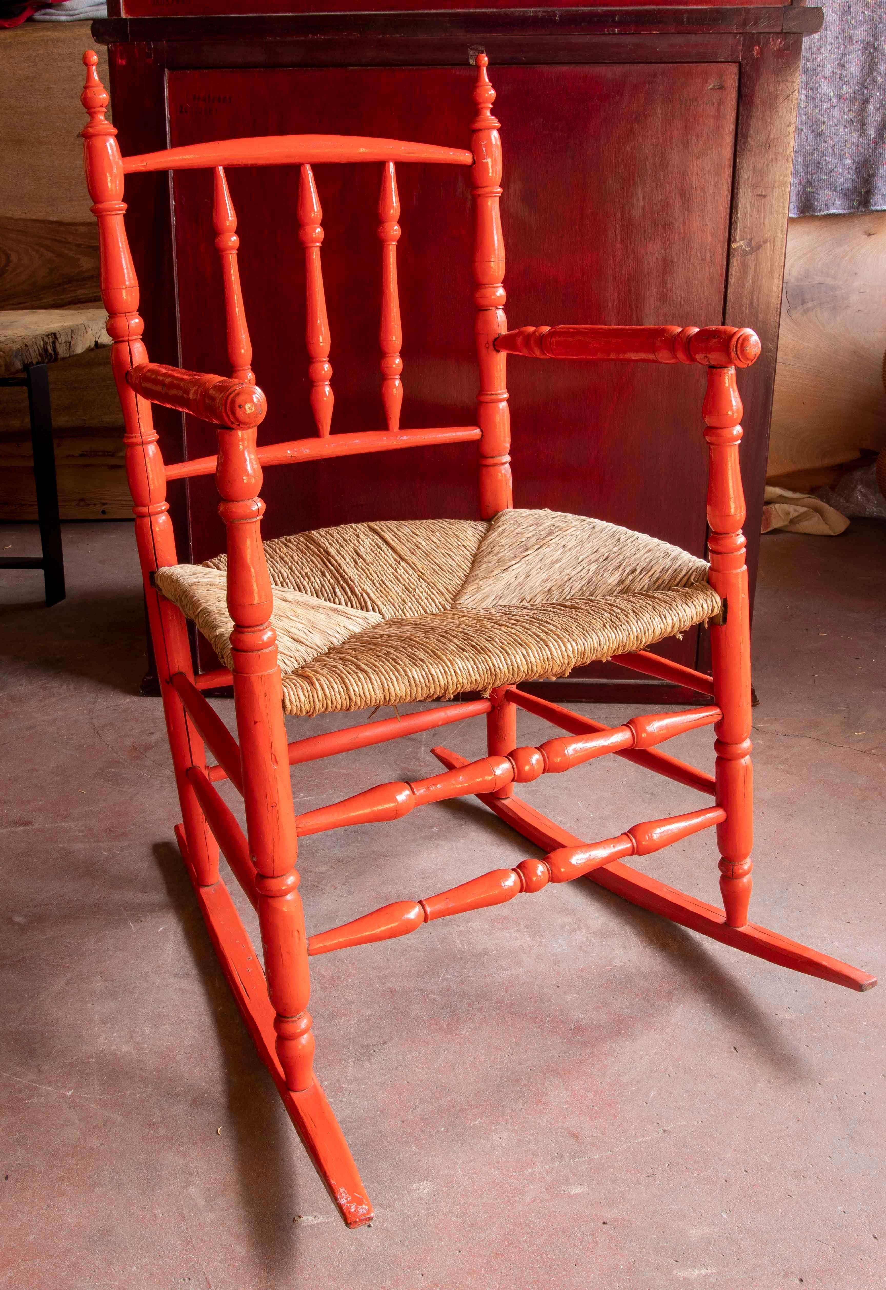 Paire de fauteuils à bascule en bois de style espagnol avec jonc et peints en rouge