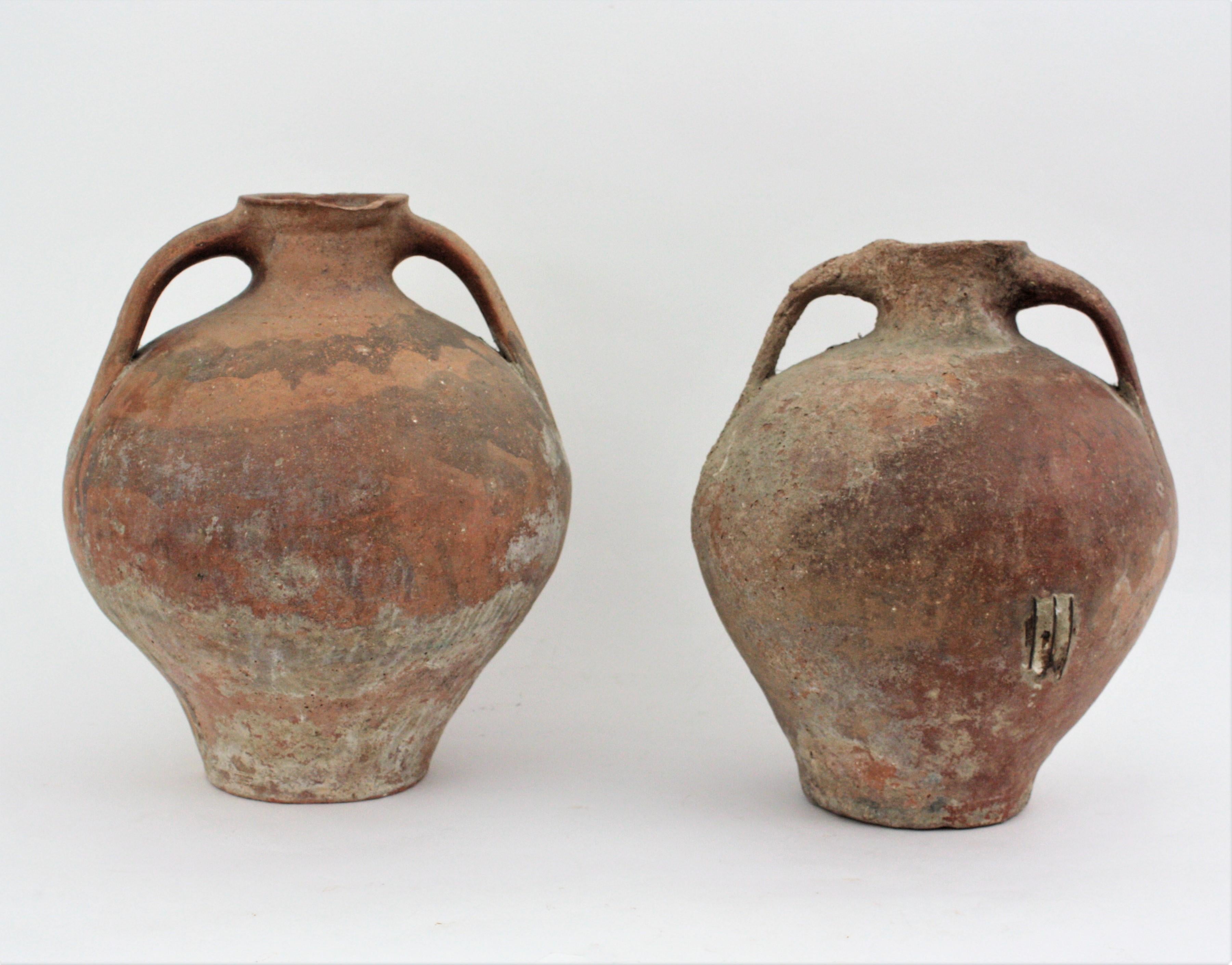 Handmade terracotta two-handled water jars / pitchers, Spain, 1880s-1930s.
Two Traditional Spanish terracotta pitchers. Unglazed exterior and interior with handles at both sides. Used as water containers. Terrific antique patina with antique