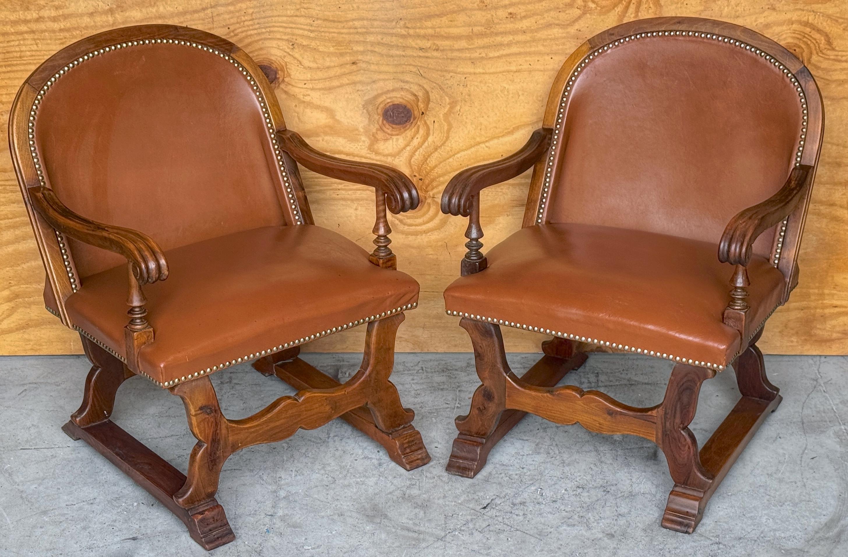Intagliato Coppia di poltrone spagnole in noce e pelle con decorazioni a chiodo, CIRCA 1920 in vendita