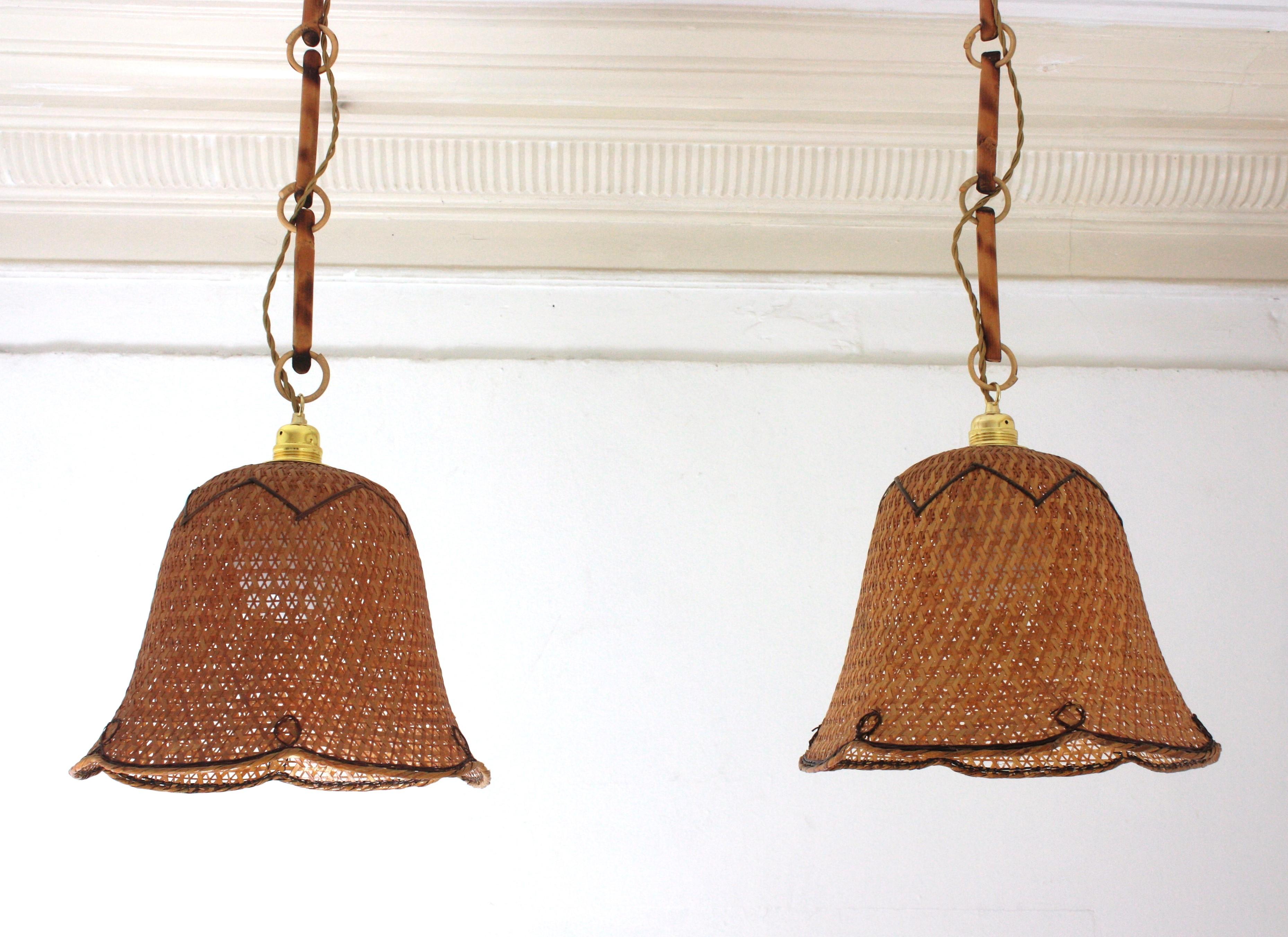 Lampade a sospensione moderniste spagnole in vimini intrecciato con paralumi a campana, Spagna, anni '60.
Accattivanti lampade a sospensione in vimini e rattan realizzate a mano con design a campana e gusto bohémien.
Sono appesi a catene fatte di