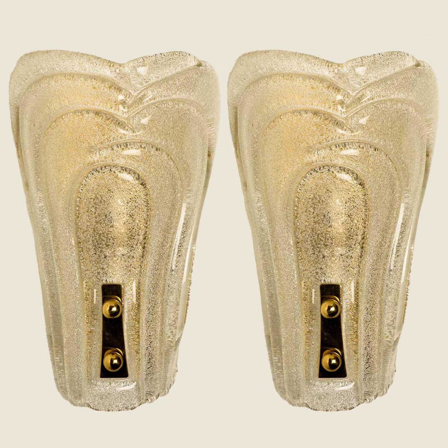 Paire de magnifiques appliques en verre scintillant, conçues par Hillebrand, 1970. Le verre richement texturé donne un éclat merveilleux. Le verre est monté sur une plaque arrière en laiton.

Nettoyé, bien câblé et prêt à être utilisé.
Chaque lampe