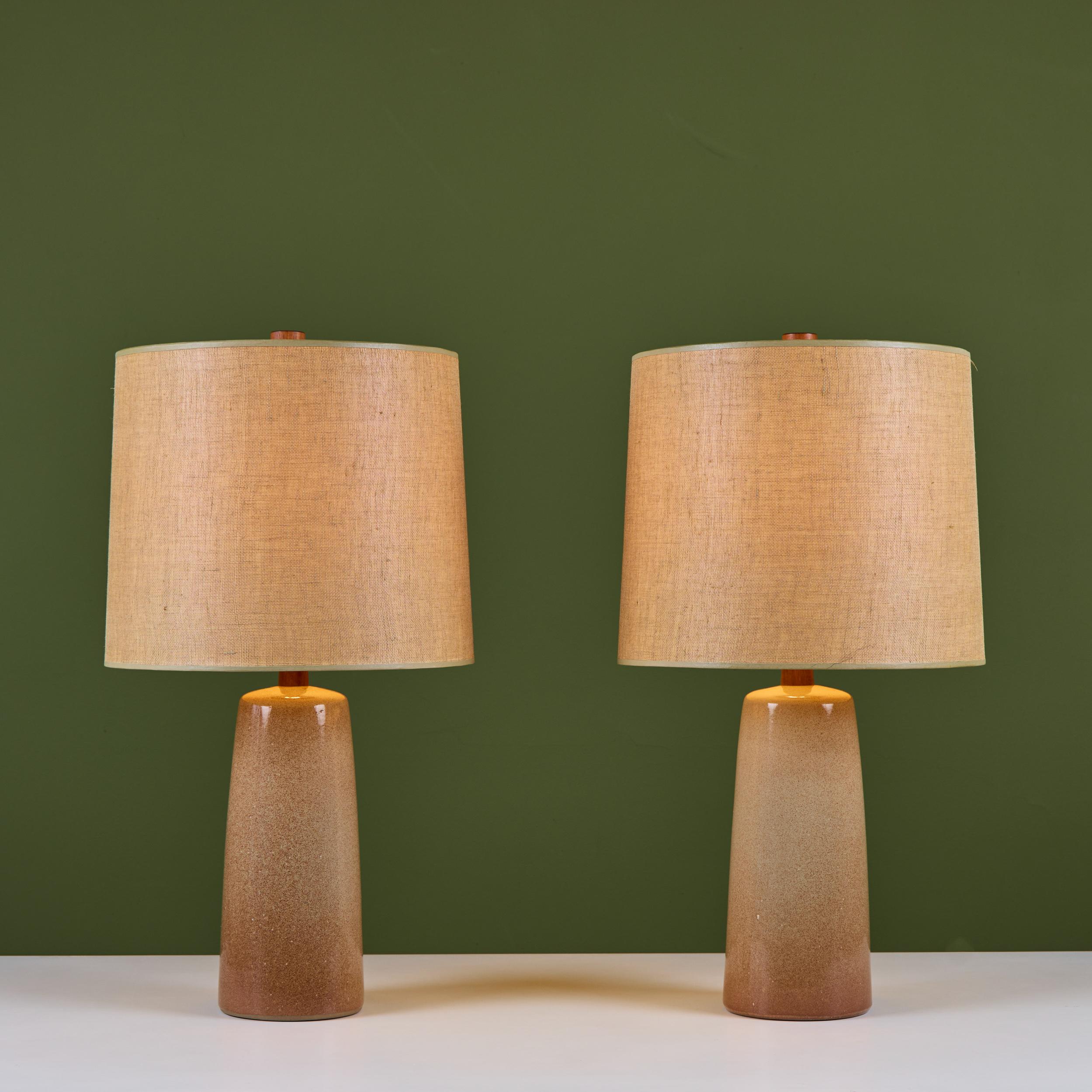 Paire de lampes en céramique du couple de designers Gordon et Jane Martz. Produit par leur entreprise familiale, les Marshall Studios dans l'Indiana à partir de 1957. Les lampes sont recouvertes d'une glaçure mouchetée crème et feu avec un embout en
