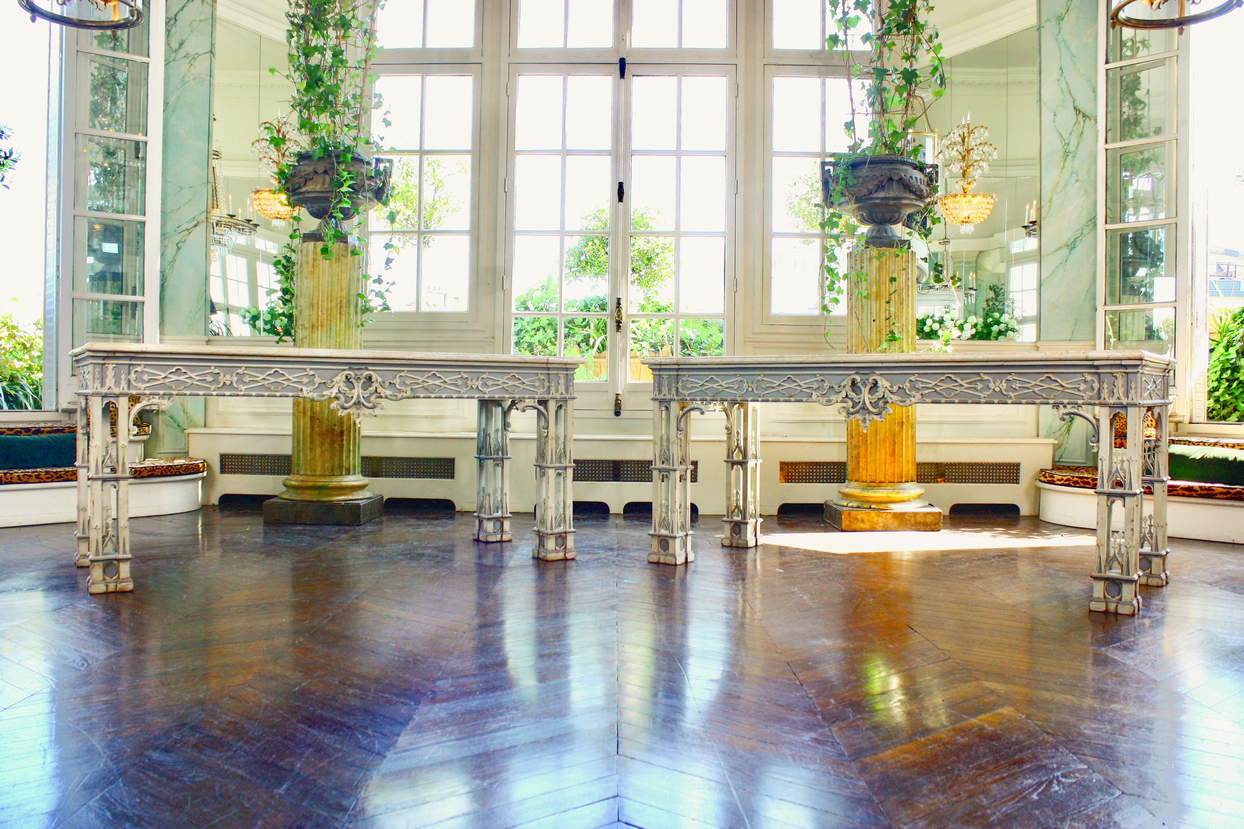 Pair of important rectangular console tables in carved wood, lacquered in white and grey with neo-Gothic decoration. The apron with interlaced frieze centered by a foliate motif. Beige veined marble tops inlaid with grey marble fillets.

In the