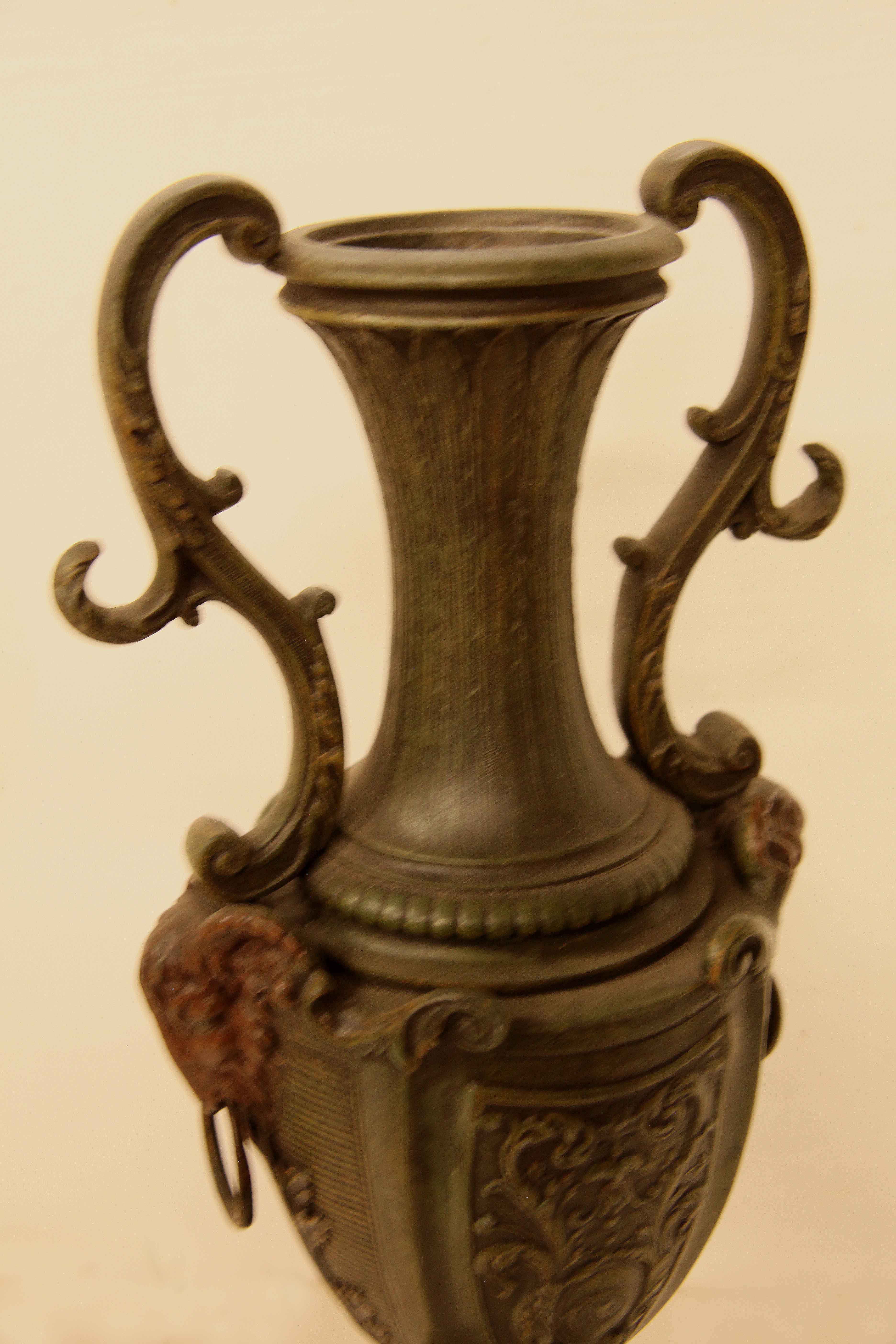 Pair of spelter and marble vases,  these vases have a classic baluster shape, the top portion with serpentine shaped handles on each side, the upper body with raised foliate design , the center with shield shaped cartouche with foliate, arabesques,