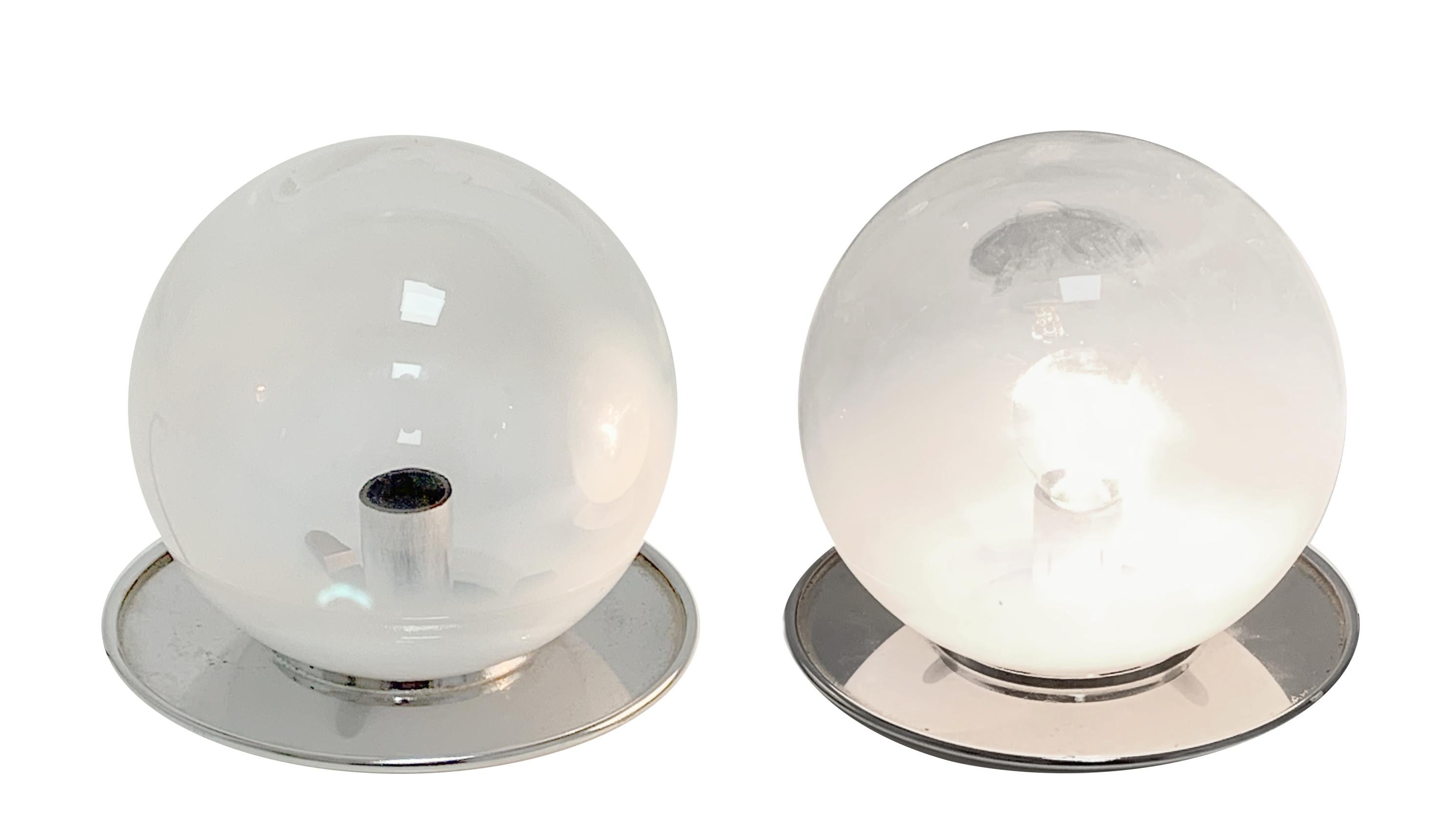 Amazing pair of midcentury spherical Murano glass table lamps with chromed metal base. This wonderful set was designed during the 1970s in Murano, Venice.

The essential nude chromed metal base integrates wonderfully with the superb mouth-blown