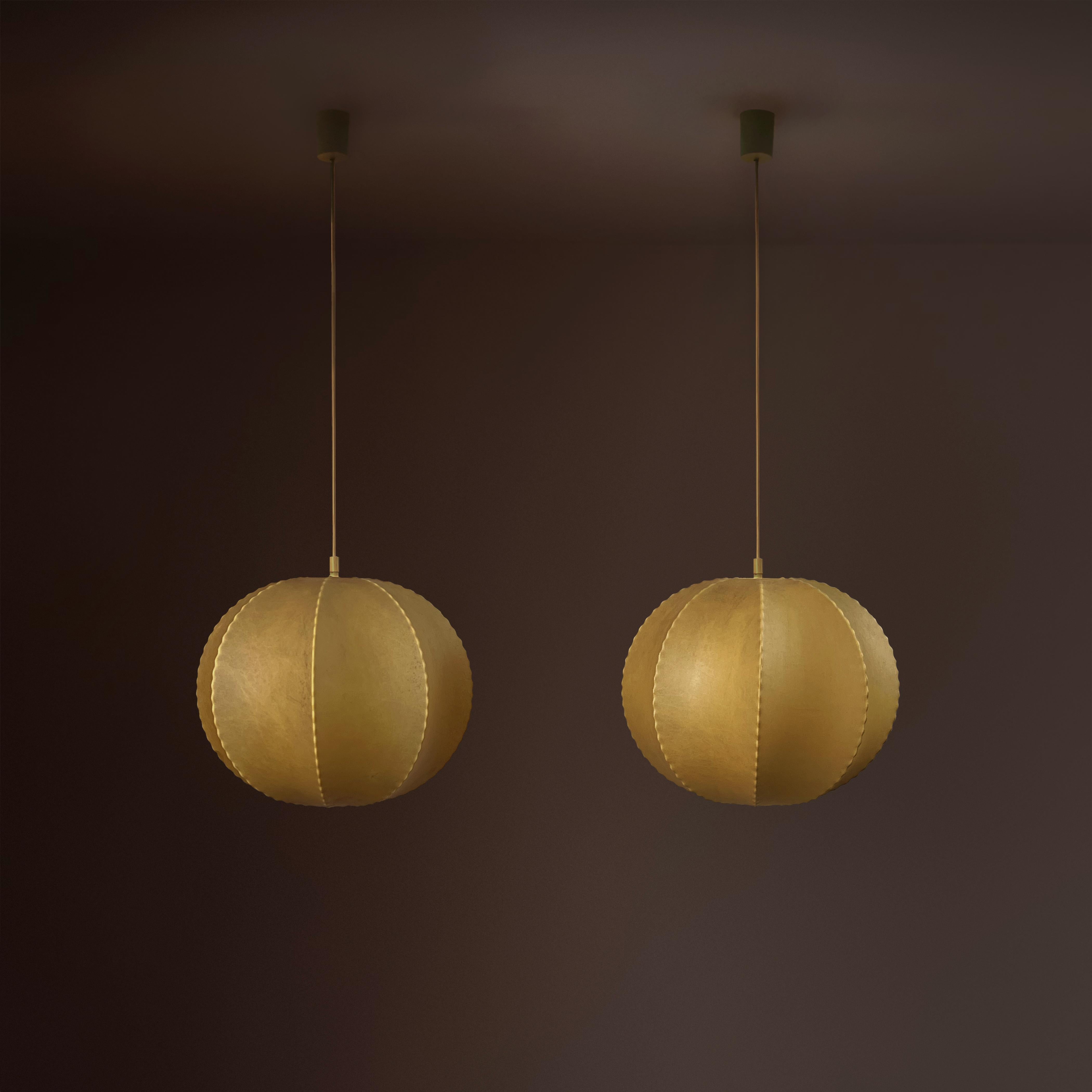 Unter den verschiedenen Kokon-Deckenlampen in unserer Sammlung sind diese beiden kugelförmigen, Friedel Wauer zugeschriebenen und in Deutschland hergestellten Lampen wirklich außergewöhnlich. 

Mit einem Durchmesser von jeweils ca. 30 cm haben sie